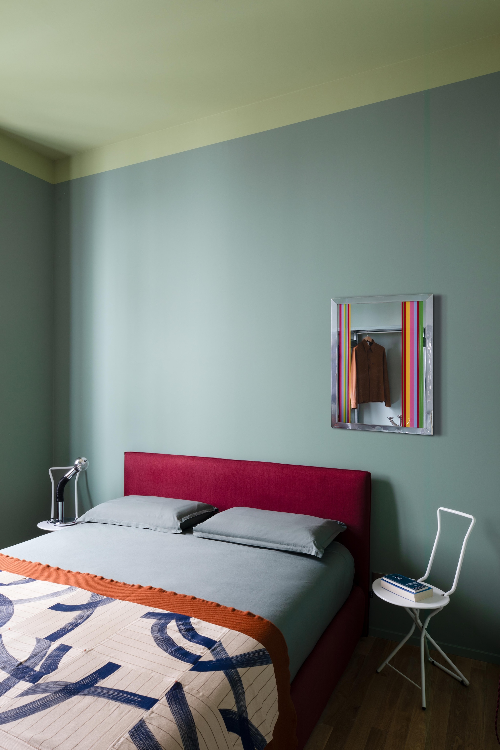 Bed Gaya Plane van Bolzan. Sprei Loads of Lines Blanket #8 van Redduo. Gestreepte vintage spiegel, tafellamp Elbow van Mario Bellini voor Targetti en vintage stoel Dafne van Gastone Rinaldi voor Thema via Gaiahomeproject. vtwonen Design 06-2026 | fotografie Monica Spezia