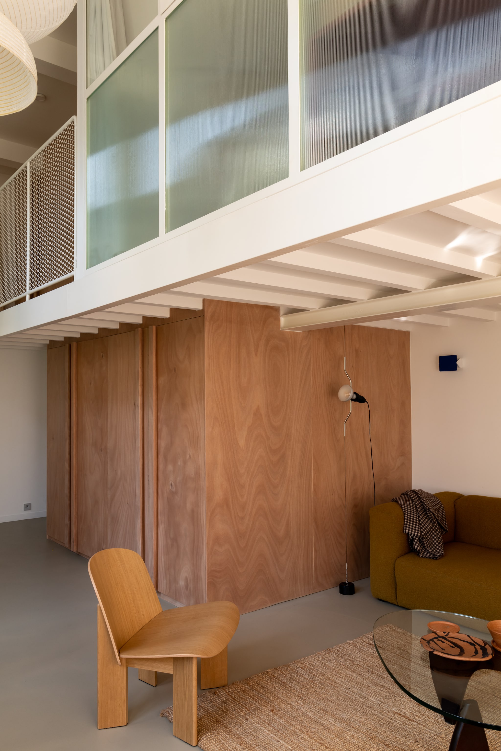 Fauteuil Chisel van Andreas Bergsaker voor Hay. Vloerlamp Parentesi van Achille Castiglioni en Pio Manzù voor Flos. Bank Mags Soft van Hay, bekleed met Flamiber Olive E9 stof. Salontafel in Noguchi-stijl. Keramiek handgemaakt in Oaxaca, Mexico. vtwonen Design 06-2026 | fotografie Agathe Tissier | productie Living Agency