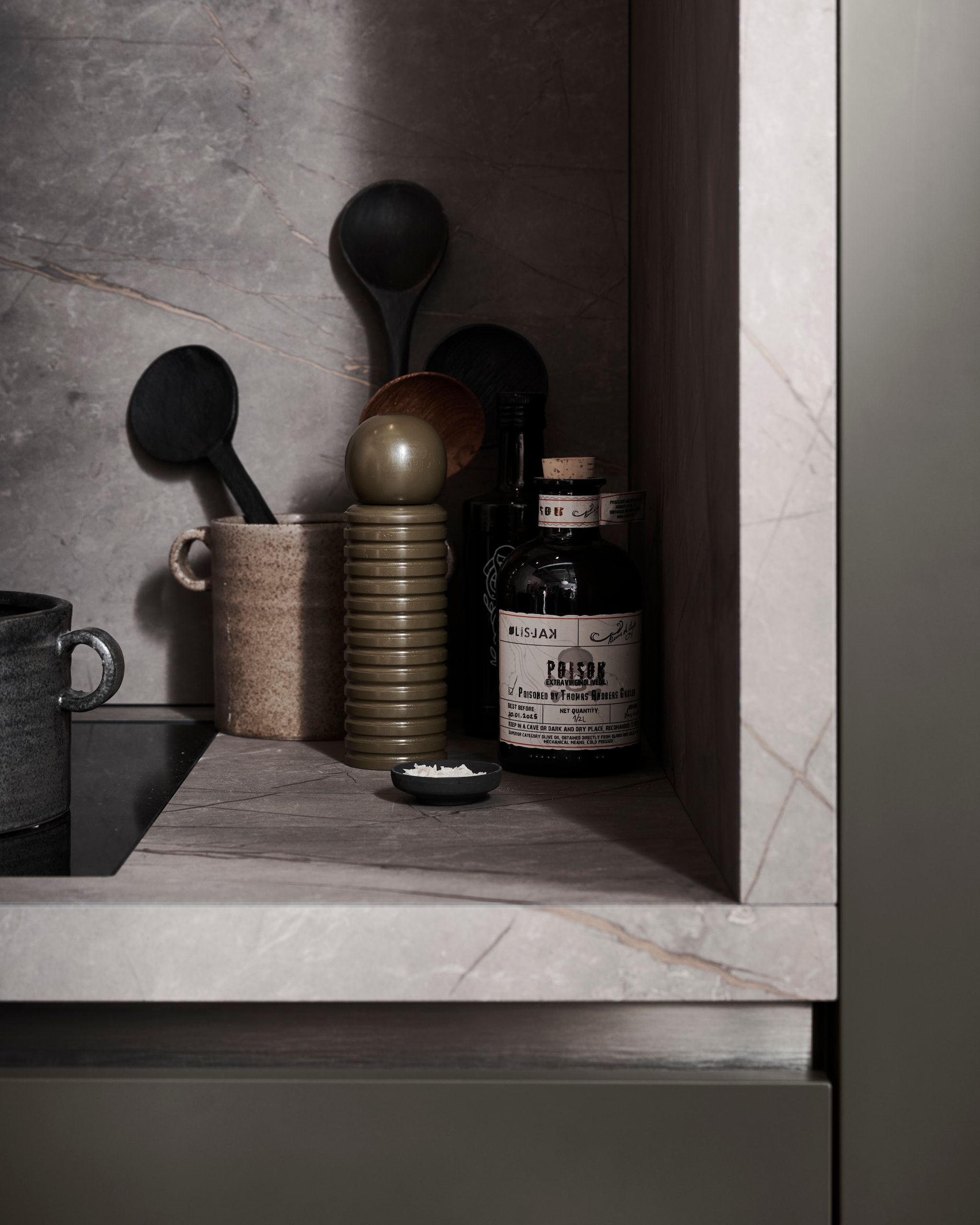 M.m.v. pure-original.com (muurverf Fresco kalkverf sand storm, lakverf Traditional Paint Eggshell fondant), vtwonen.nl (vloertegel Composite dark grey van vtwonen), hetkabinet.nl (eetkamerstoel Lara, oude onbehandelde kruk), zarahome.com (houten dienblad aan de wand, vloerkleed, linnen geruit tafelkleed, servet), loods5.nl (oude vaas), kare.nl (barkrukken), frandsen.com (hanglamp Benjamin). Overig privébezit. vtwonen 05-2026 | styling Kim van Rossenberg | fotografie Sjoerd Eickmans