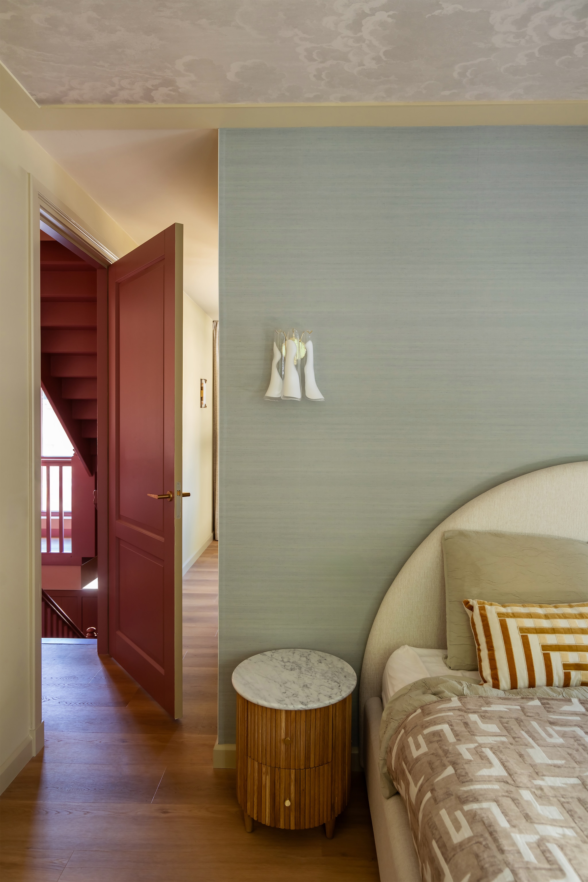 Behang Moonstone van Designers Guild. Nachtkastje Loods 5. Bed, beddengoed en sprei Westwing. Verfkleur deur Ashes of Roses van Little Greene. Verfkleur plafond Light Stone van Farrow & Ball. Behang plafond Fornasetti Nuvolette 114/28056 van Cole & Son. Wandlamp Etsy. Kussen Karwei. vtwonen Design 06-2026 | styling Juliette de Dreu | fotografie Lotte van Uittert