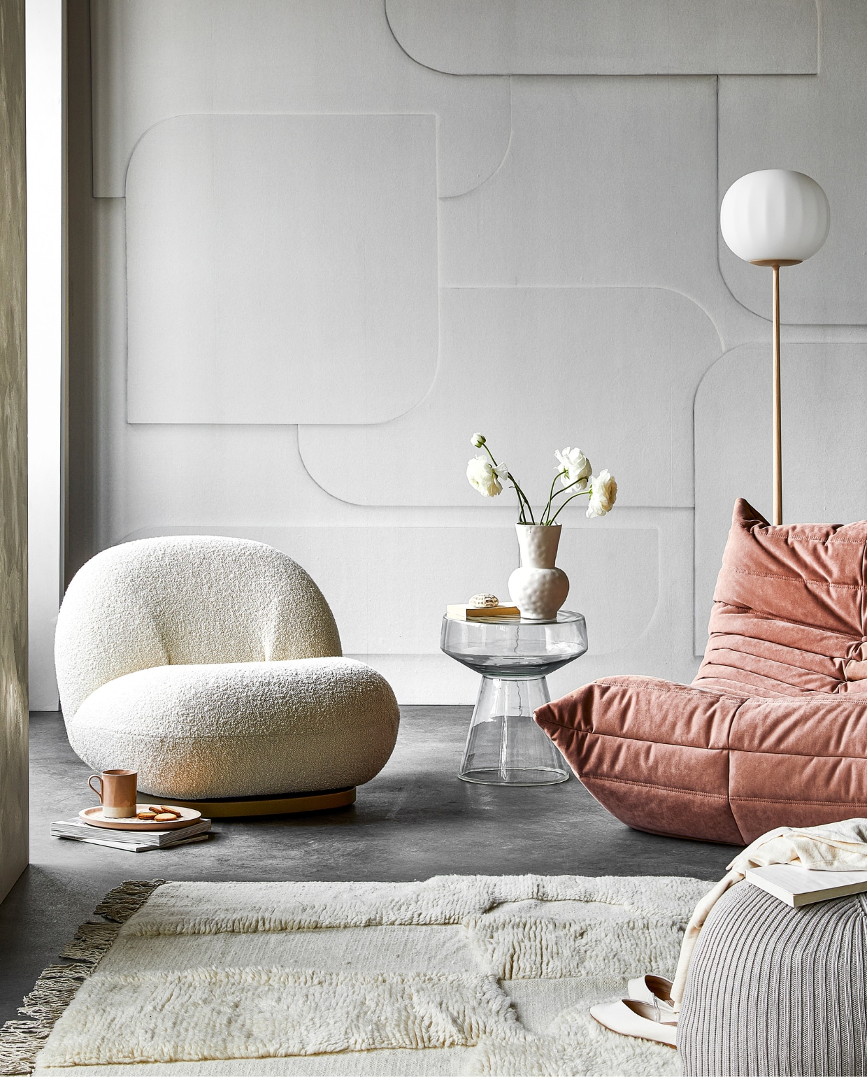 Digitaal behang Soft 3D light grey, 6 banen van 280×50 cm, totaal (lxb) 280×300 cm € 149,-. M.m.v. kasstoor.nl (witte fauteuil, roze fauteuil, vloerlamp), homestede.nl (houten dienblad, poef), paviljoennoord.com (mok, shirt), loods5.nl/design (glazen bijzettafel), zara.com (vaas, schoenen), hm.com (vloerkleed), pure-original.nl (muurverf Freso in kleur Sea Salt). Overig privébezit. vtwonen 05-2021 | productie Tanja Saarberg | styling Danielle Verheul | fotografie Peggy Janssen