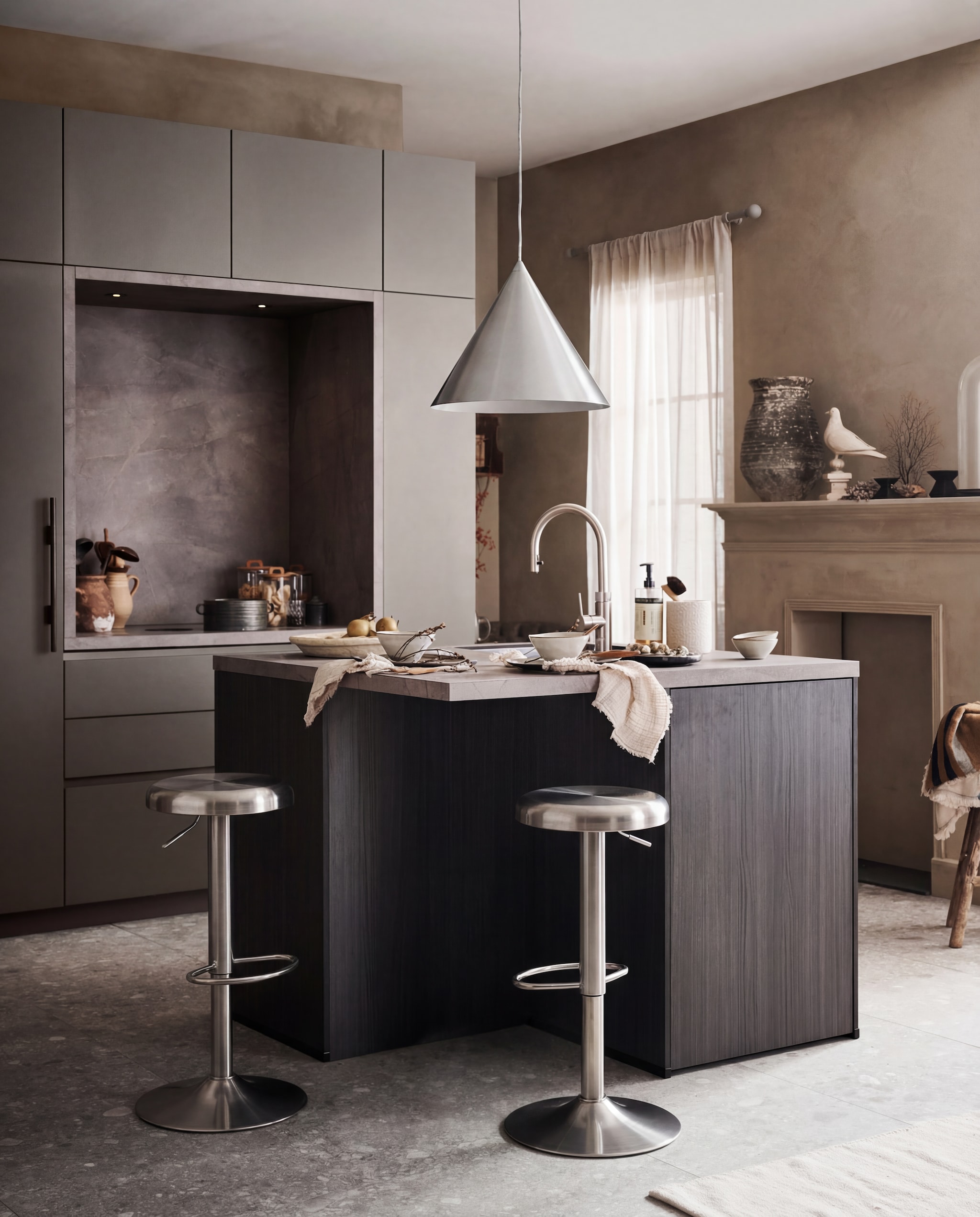M.m.v. pure-original.com (muurverf Fresco kalkverf sand storm), vtwonen.nl (vloertegel Composite dark grey van vtwonen), hetkabinet.nl (oude kruk, houten mand, stolp, oude eierschaal, beige schaal, metalen pollepels, houten kandelaars op schouw, houten beeld duif), zarahome.com (vloerkleed, servetten, glazen potten met houten deksel), kare.nl (barkrukken), frandsen.com (hanglamp Benjamin), vandijkenko.nl (oude karaffen), humdakin.com (zandstenen houder, afwasmiddel, afwasborstel), nordal.com (servies, zwarte pan), demuseumwinkel.com (zeewaaier op voet), loods5.nl (oude vaas), libecohomestores.eu (theedoek). Overig privébezit.Wacht! vtwonen 05-2026 | styling Kim van Rossenberg | fotografie Sjoerd Eickmans