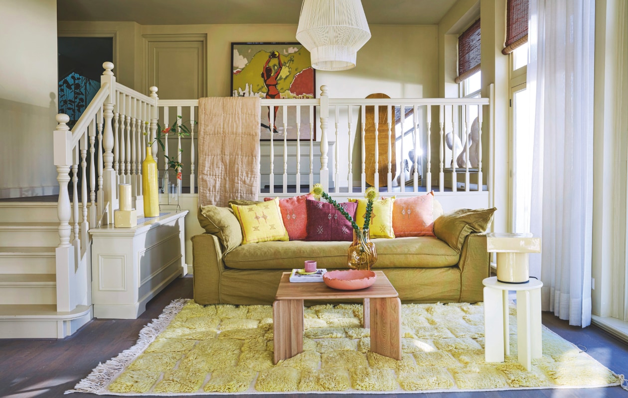 Linnen driezitsbank Nomad in Burnt Ochre € 3025,-, schilderij met plexiglazen lijst Playground € 696,-, rotan wanddecoratie Sun € 395,-, plaid Quilted in Sand € 109,- (hkliving.com). Eiken salontafel Soft 90 € 649,-, eiken bijzettafel Soft 32 in gele lak € 289,-, keramieken tafellamp Display € 349,-, keramieken vaas Display in botergeel € 99,- (studio-henk.nl). Wollen vloerkleed Beni Mguild € 790,-, diverse kussens € 44,95 per stuk (rozenkelim.nl). Spiegel Shine van Hübsch € 290,- (shop.vtwonen.nl). Lampionlamp No1 L in Natural, gerecycled plastic € 169,95 (originalhome.nl). Keramieken kopje Iron € 20,-, keramieken schaal Edge € 420,-, keramieken bord Cookie in Yellow € 22,- (studioefg.nl). Overig privébezit. vtwonen 06-2025 | styling Kelly van Gendt | fotografie Peggy Janssen