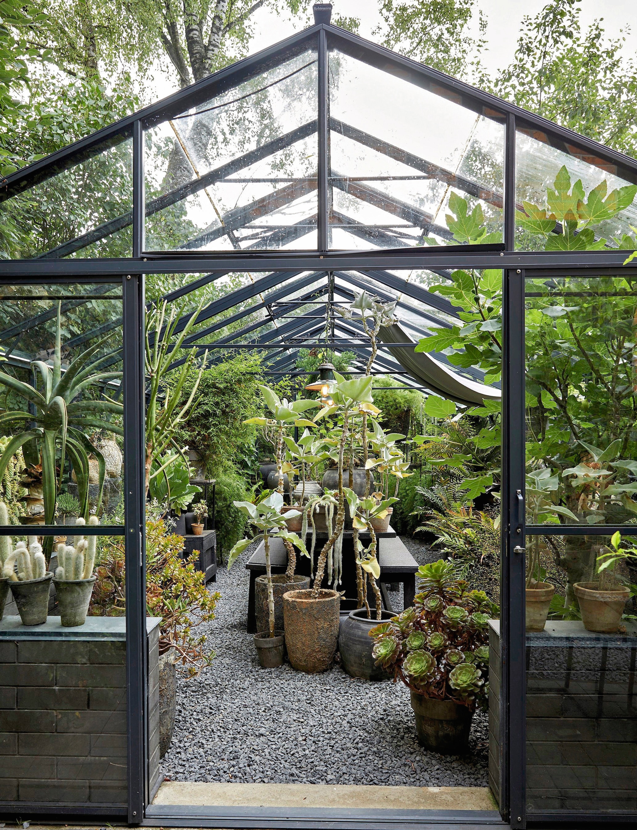 Kas Gewächshausplaza. Meubels in de kas zelf gemaakt. Lampen en potten van vlooienmarkten. vtwonen landelijk 03-2026 | fotografie Peter Fehrentz