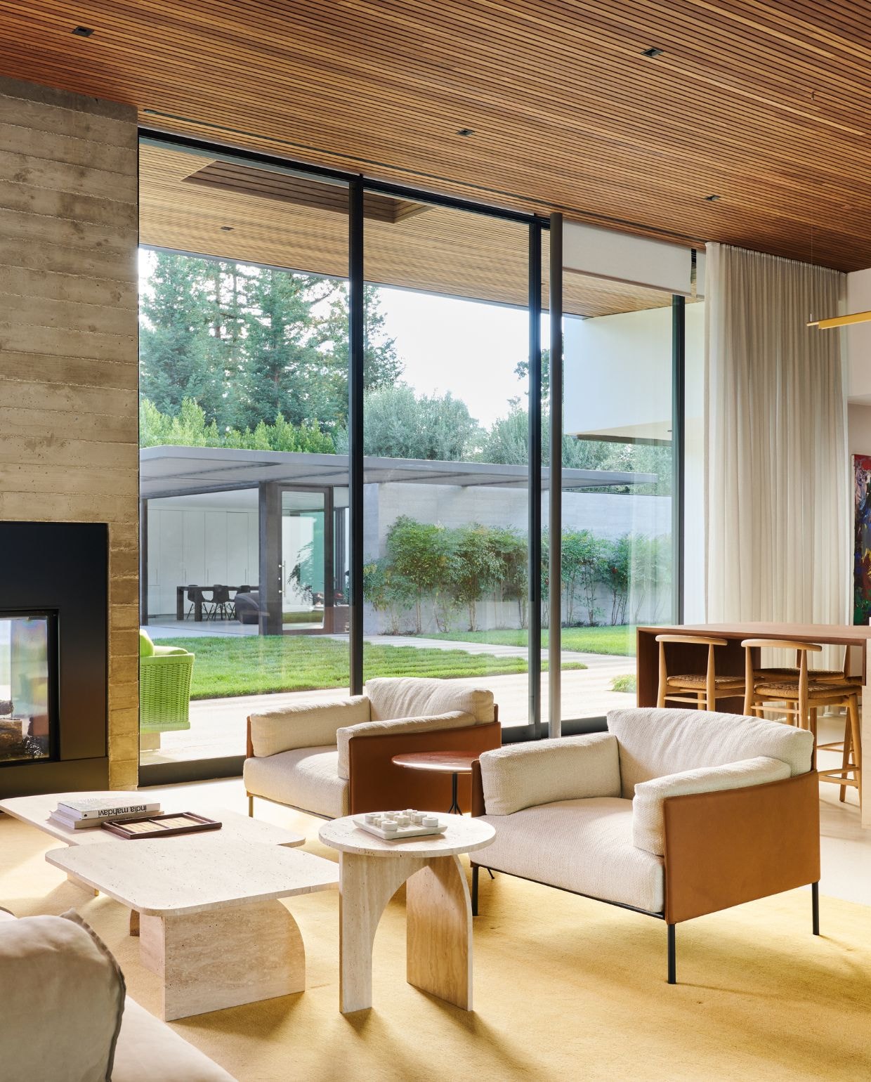 Fauteuils en ronde bijzettafel Living Divani. Bijzettafel Draga & Aurel voor Baxter. Travertijn koffietafels Gallotti & Radice.