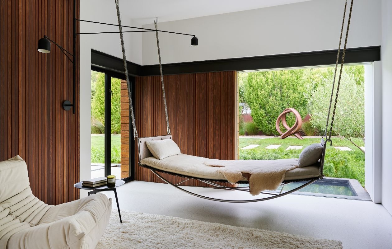 Daybed Jim Zivic voor Ralph Pucci. Lamp Karakter Copenhagen. Vloerkleed Woven. Fauteuil Ligne Roset. Teakhouten wand. Bijzettafel Minotti. vtwonen Design 03-2026 | fotografie Valentina Sommariva