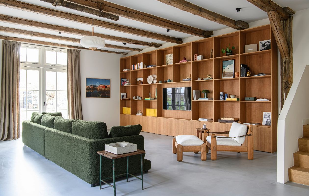 Bank Kave Home. Kast maatwerk door Ølav Houtelier. Hanglamp Westwing. Fauteuil vintage. Ronde kruk gemaakt door Nick. Gordijnen Loggere Wilpower. vtwonen 04-2026 | styling Esther Loonstijn | fotografie Louis Lemaire