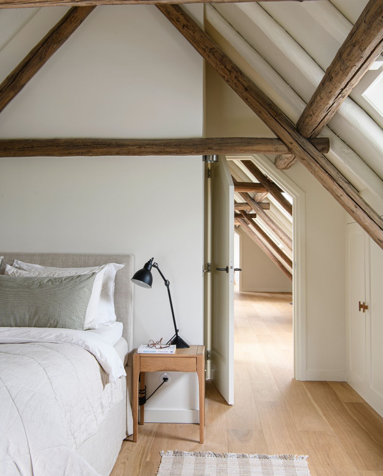 Bed Coco-Mat. Lamp Lampe Gras van Dcw Éditions. Nachtkastje Zara Home. Op de vloer ligt eiken. Muurverf School House White van Farrow & Ball.