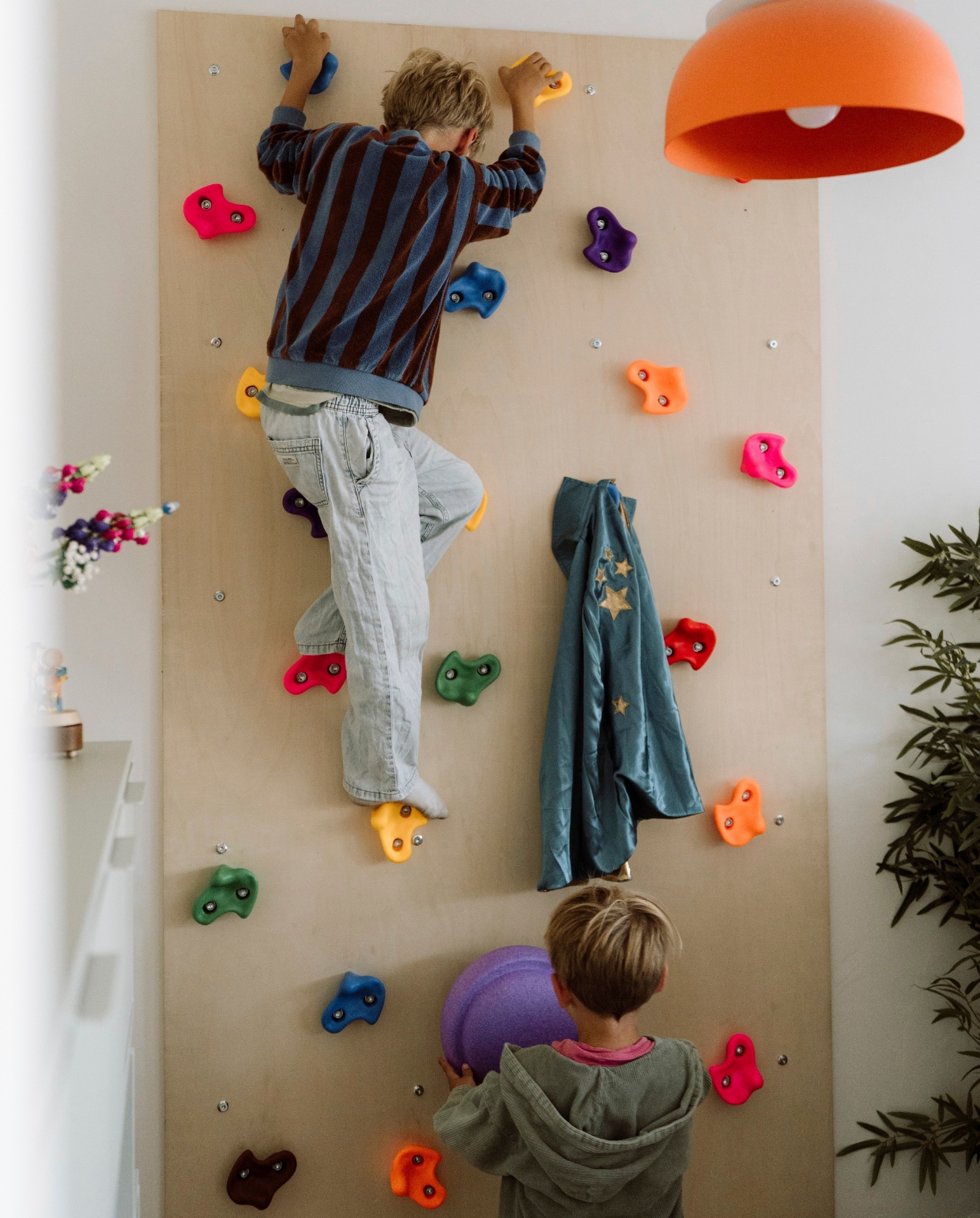 Kast Tylko. Cape Le Petit Souk. Klimwand zelfgemaakt. Stapstenen Stapelstein. Bloemen Lego. Tafeltje Kidsdepot. Vliegtuig kringloop. Mand Leenbakker.
 vtwonen 11-2025 | styling Sanne Ketelaar | fotografie Stories By Chriske