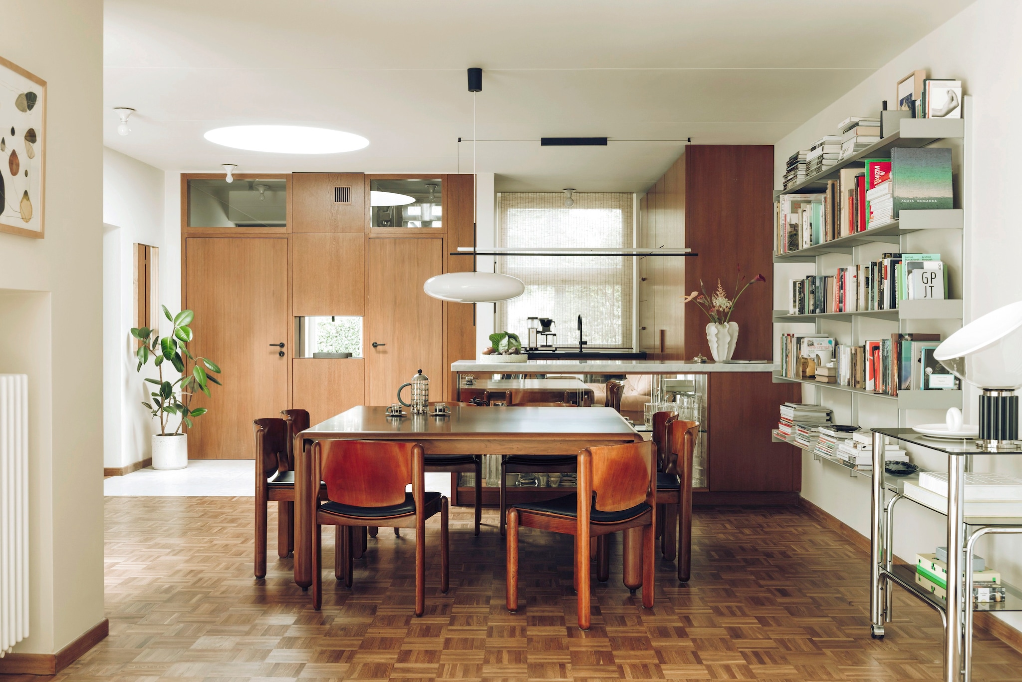 Rechte plafondlamp Lámina van Santa & Cole. Hanglamp Suspension Model 2065 van Astep. Vintage eettafel en stoelen Cassina van Vico Magistretti. Trolley vintage soortgelijk Pamono. vtwonen design 03-2026 | fotografie Oni Studio