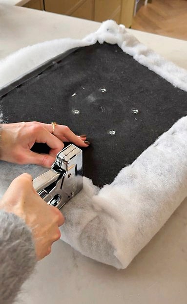 Plaid Libbe van Dutch Decor via shop.vtwonen.nl. Kunstwerk Studio Vreeken. Vloerkleed Lorena Canals. Zitkussen zelfgemaakt. Fauteuil en rolkussen tweedehands. vtwonen 04-2026 | fotografie Valerie Paas