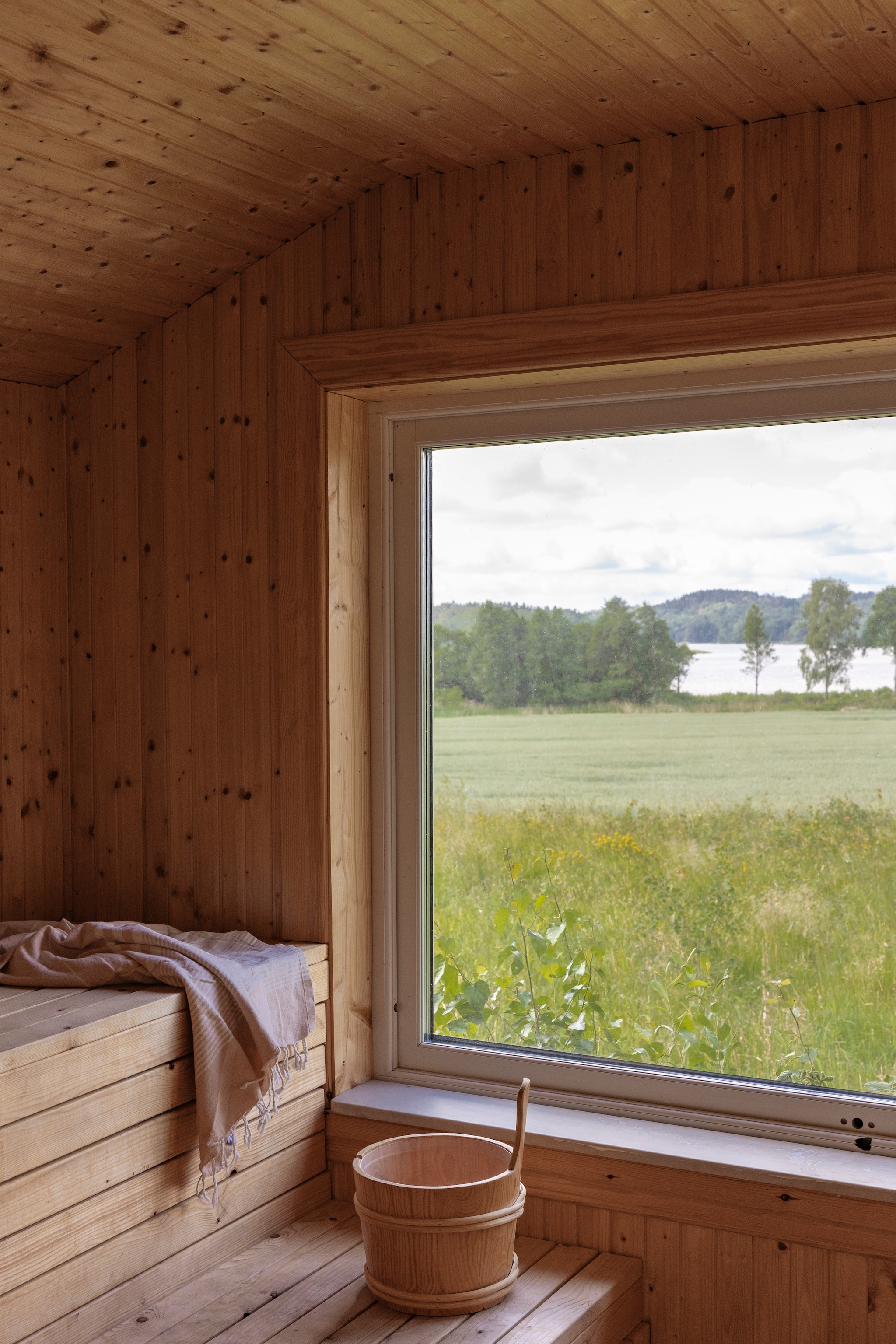 Uitzicht op Mjörn-meer vanuit de sauna. vtwonen Landelijk 07-2026 | productie Sarah MacAfie | styling Anna Bjelkholm | fotografie Anna Karlsson