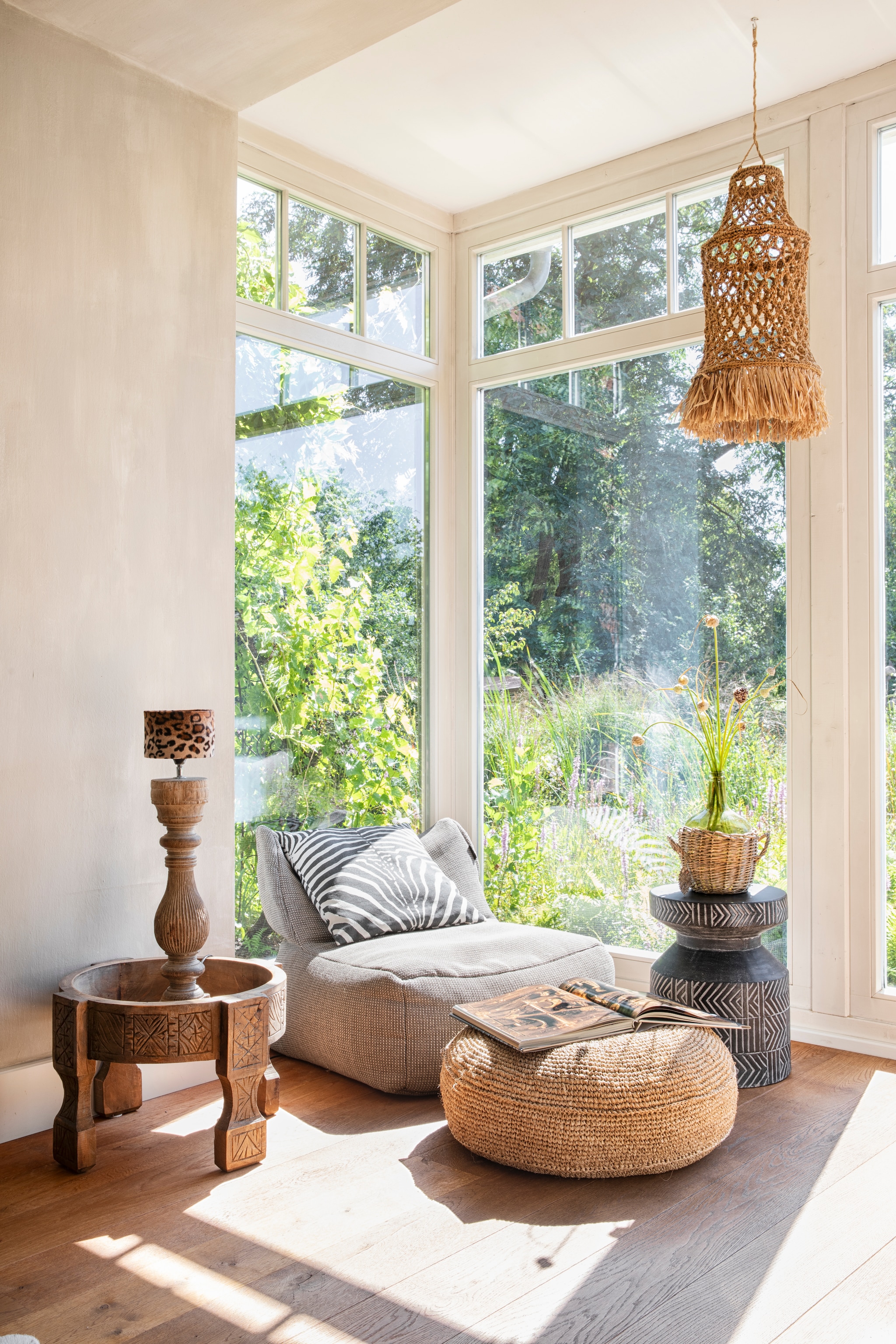 Buitenfauteuil Roolf Living. Juten hanglamp Ibiza & More.  Chakki-tafel Casa Moro. Soortgelijke bijzettafel van donker hout Woood. Poef Pilew van Sklum. Lamp van oude baluster Aura Peeperkorn via Hillary’s Home.