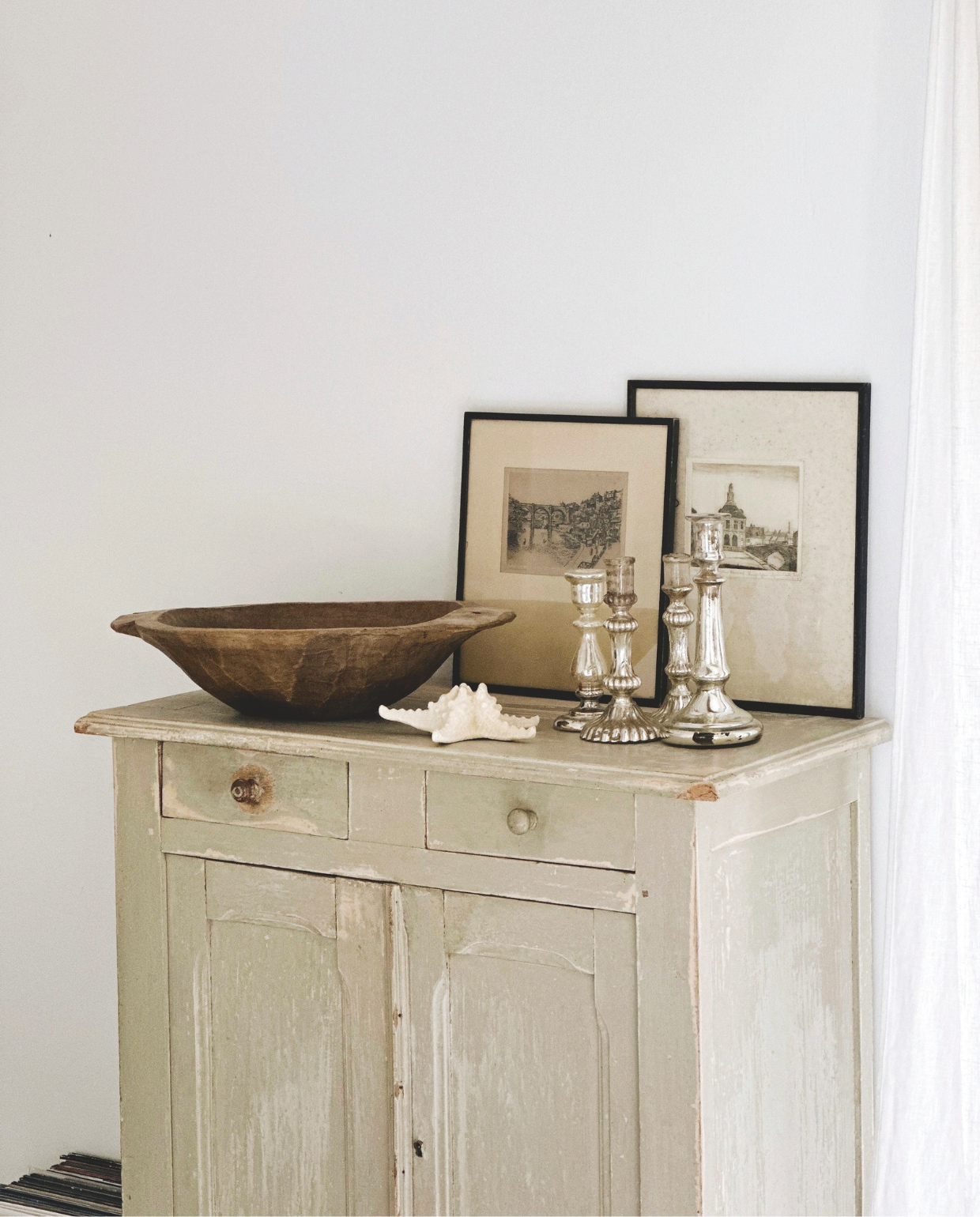 Buffetkast vintage. 19e-eeuwse verzilverde glazen kandelaars vintage. Handgesneden Hongaarse pastakom. Zeesterren uit Sardinië. Oude gravures gevonden op een rommelmarkt in Givry. vtwonen Landelijk 04-2026 | fotografie Roxanne Dupoirier