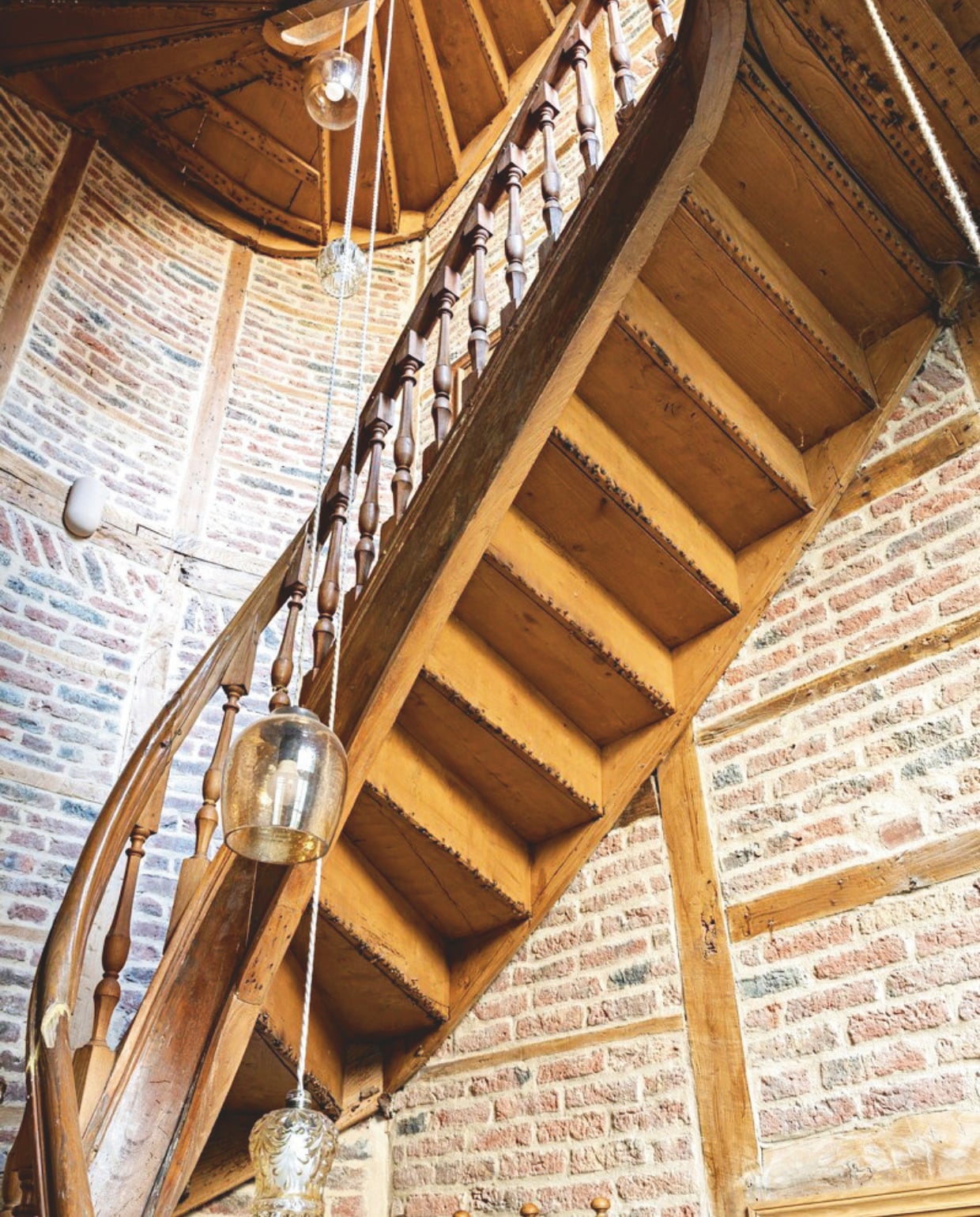 Hal met originele trap. De vakwerkmuren zijn gerestaureerd. Hanglamp Atelier Sukha. vtwonen Landelijk 04-2026 | styling Marie-Maud Levron | fotografie Yann Deret