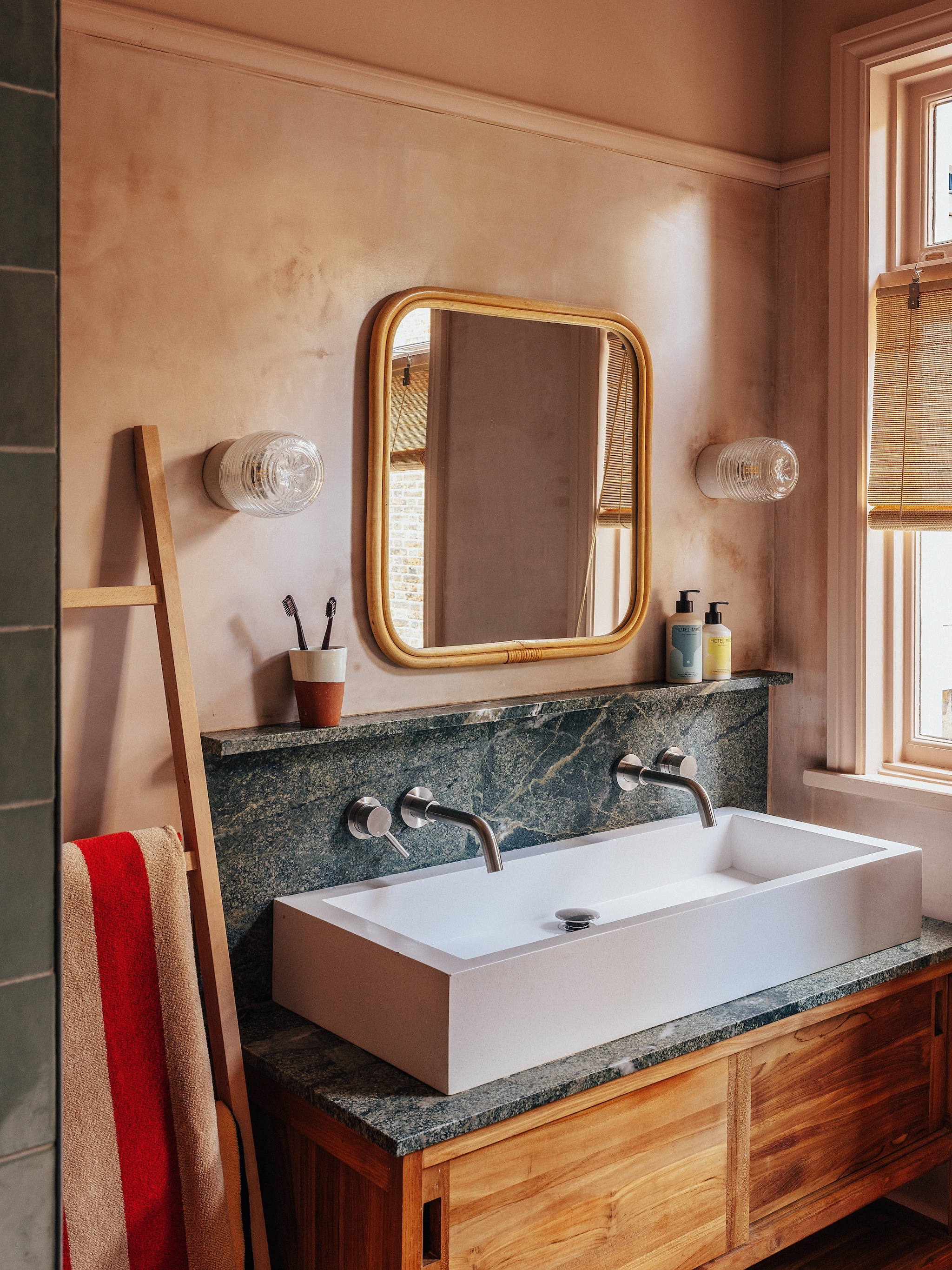 Wastafel en spiegel Tikamoon. Kranen Lusso Stone. Rolgordijnen Color & Co. Zelliges in Turchese van Parkside. Wandlampen Off White van Dyke & Dean. Badhanddoek Alee van Ferm Living. vtwonen 07-2026 | fotografie Taran Wilkhu | productie Living Inside