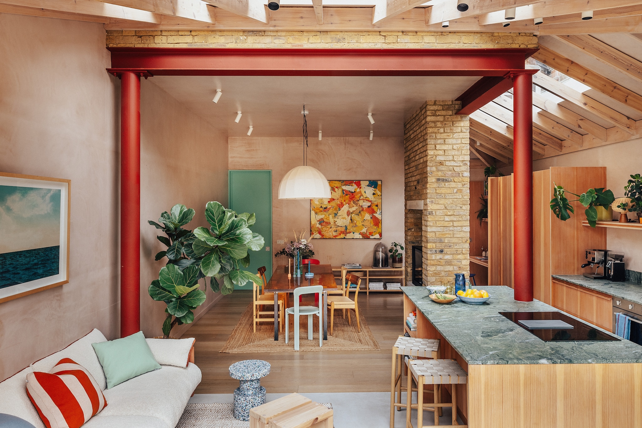 Kussens Mingle van Muuto. Gestreept kussen Sophie Home. Print Seascape 1 van Newton Blades. Alle wanden bekleed met Thistle Plaster. Tafel met een blad van hars is een prototype van Rolf Sachs. Gekleurde stoelen Rey van Hay. Houten stoelen Ch23 van Carl Hansen & Søn. Stoelen gevlochten zitting Soft van Takt. Schilderij Thea’s van Tom Robinson via Messums Gallery. Kleur deur Arsenic van Farrow & Ball. Vloerkleed La Redoute. vtwonen 07-2026 | fotografie Taran Wilkhu | productie Living Inside