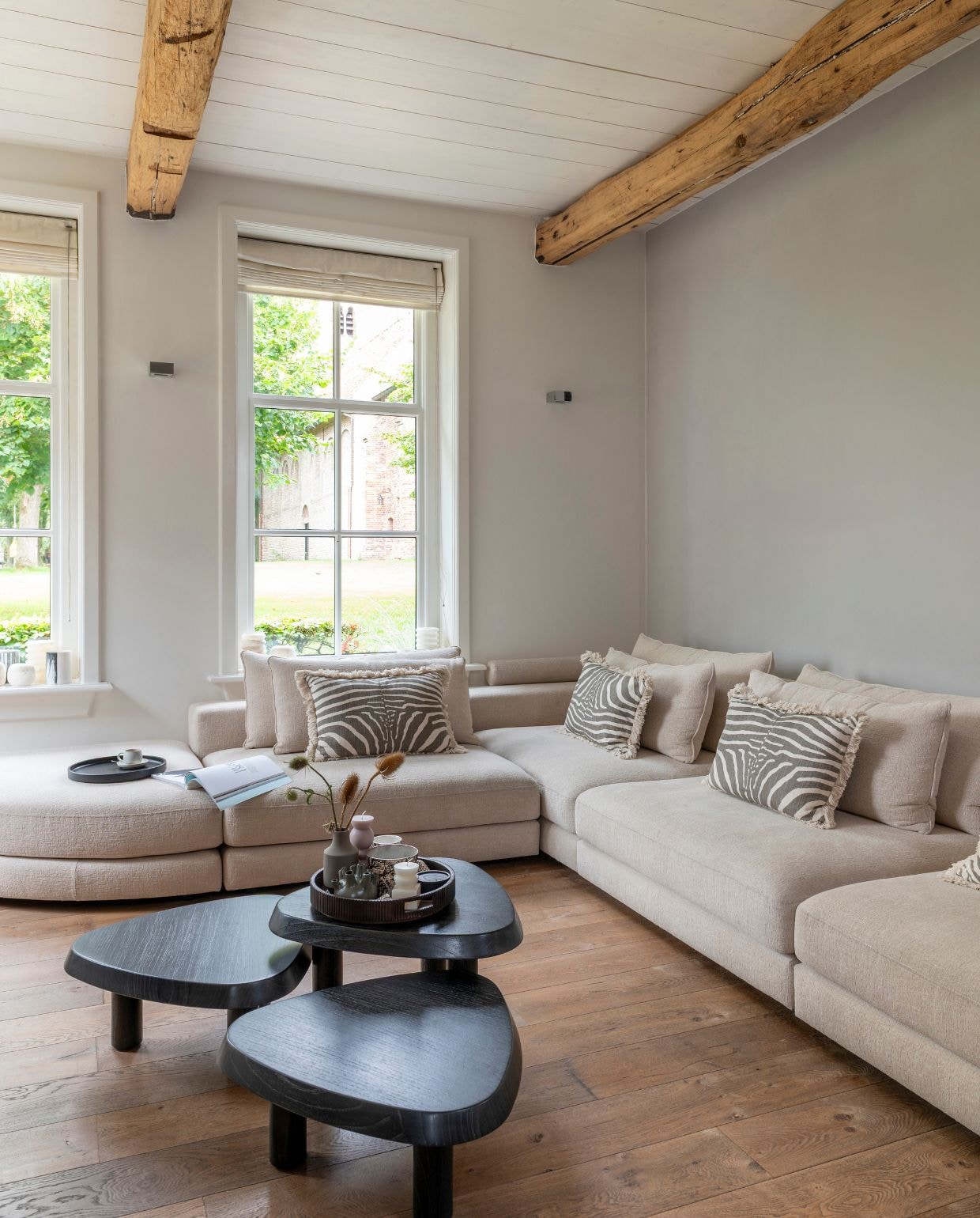 Rolgordijnen Reitsema in Annen. Modulebank en salontafels Eichholtz. Kussens, dienblad envazen op salontafel H&m Home. Dienblad op bank Cookx. vtwonen Landelijk 03-2026 | fotografie Suzanne Paap