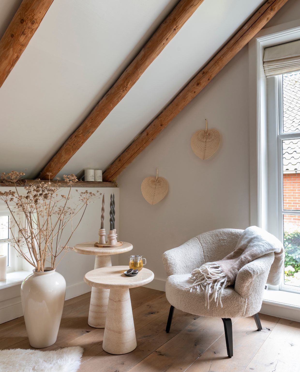 Travertin bijzettafels en stoel Eichholtz. Vaas H&m Home. Plaid en kandelaars Westwing. Vacht Native Natural. vtwonen Landelijk 03-2026 | fotografie Suzanne Paap