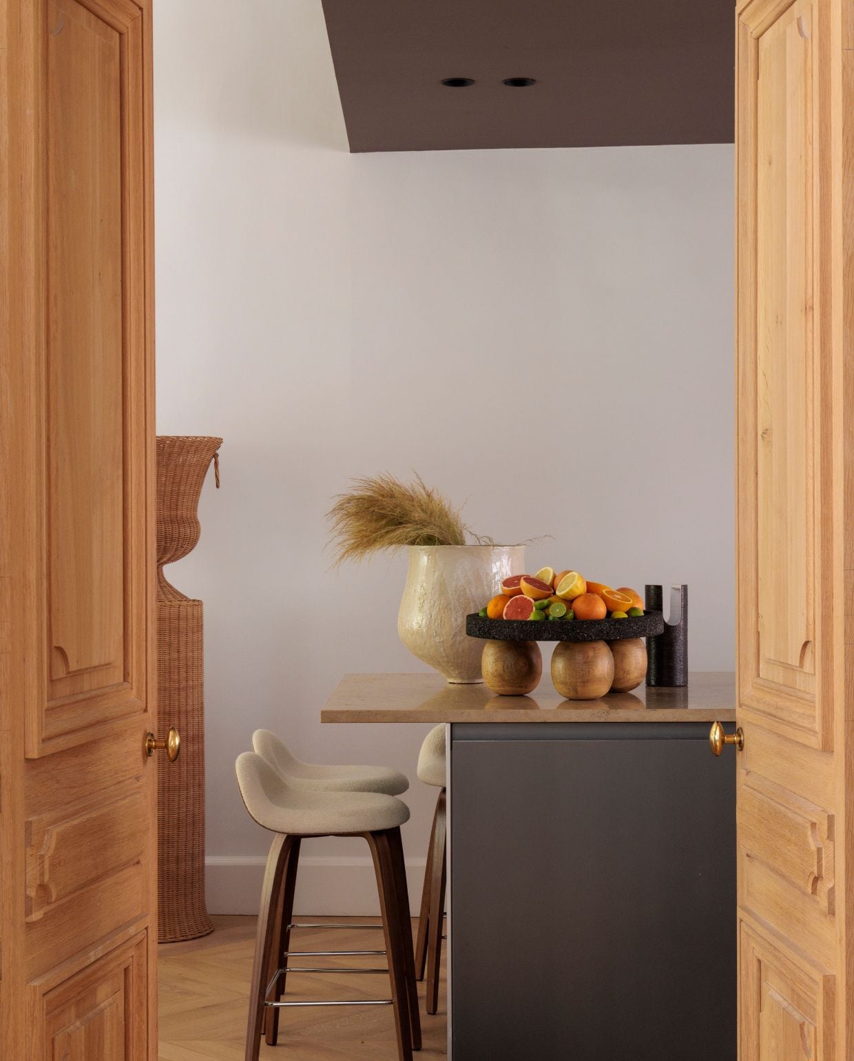 Keuken Bulthaup. Keukenloper Cc-tapis. Barkrukken Gubi. Muur- en plafondverf Ressource Peintures. Vaas Lisa Chamoun. Fruitschaal Daniel Orozco. Pilaar met vaassculptuur Atelier Vime. vtwonen Design 03-2026 | fotografie Guillaume Grasset