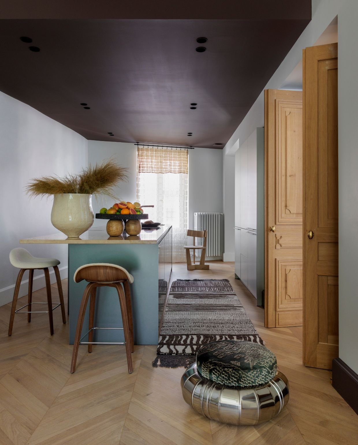 Keuken Bulthaup. Keukenloper Cc-tapis. Barkrukken Gubi. Poef Tacchini. Muur- en plafondverf Ressource Peintures. Vaas Lisa Chamoun. Fruitschaal Daniel Orozco. vtwonen Design 03-2026 | fotografie Guillaume Grasset