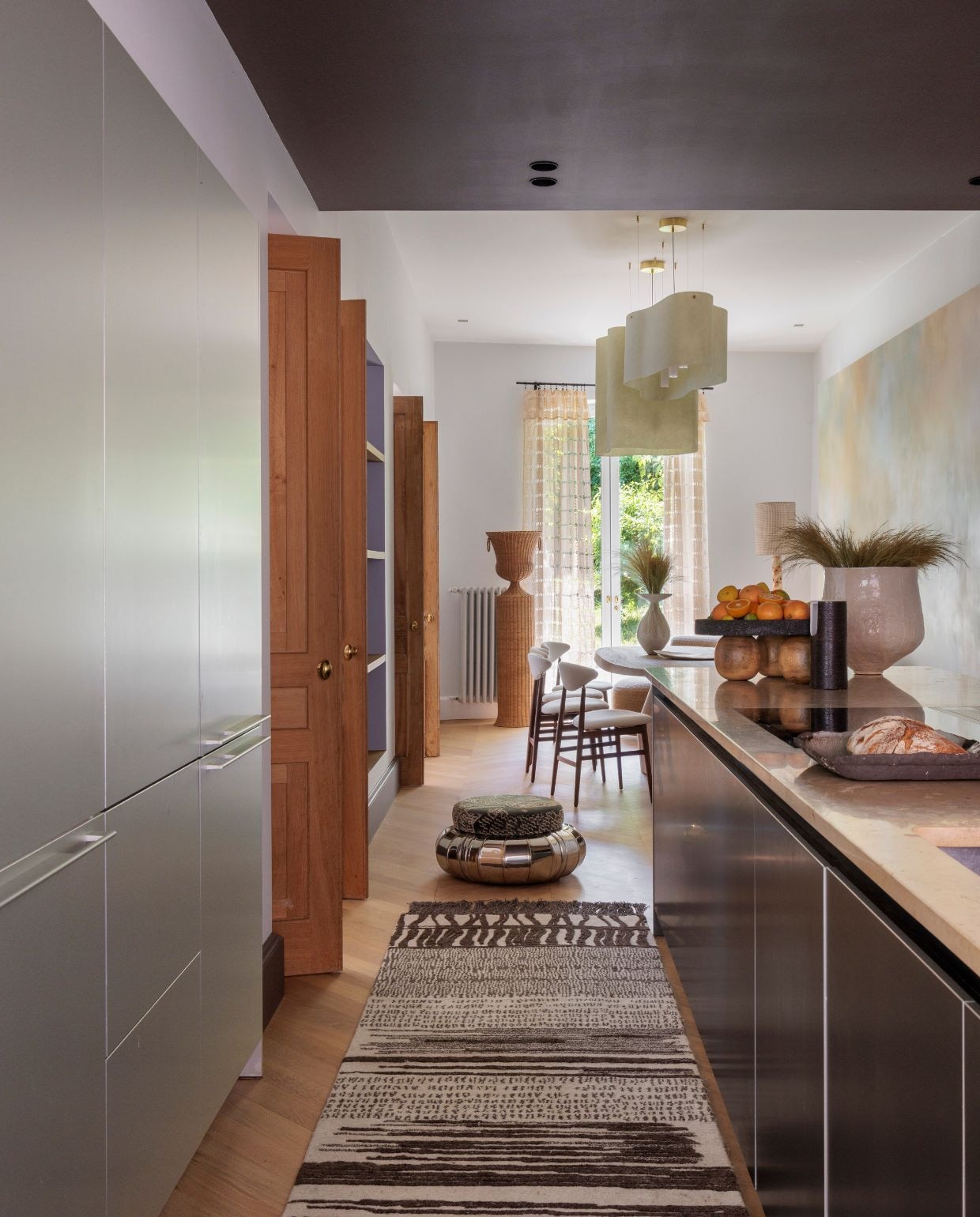 Keuken Bulthaup. Keukenloper Cc-tapis. Poef Tacchini. Muur- en plafondverf Ressource Peintures. Vaas Lisa Chamoun. Fruitschaal Daniel Orozco. Pilaar met vaassculptuur Atelier Vime. vtwonen Design 03-2026 | fotografie Guillaume Grasset