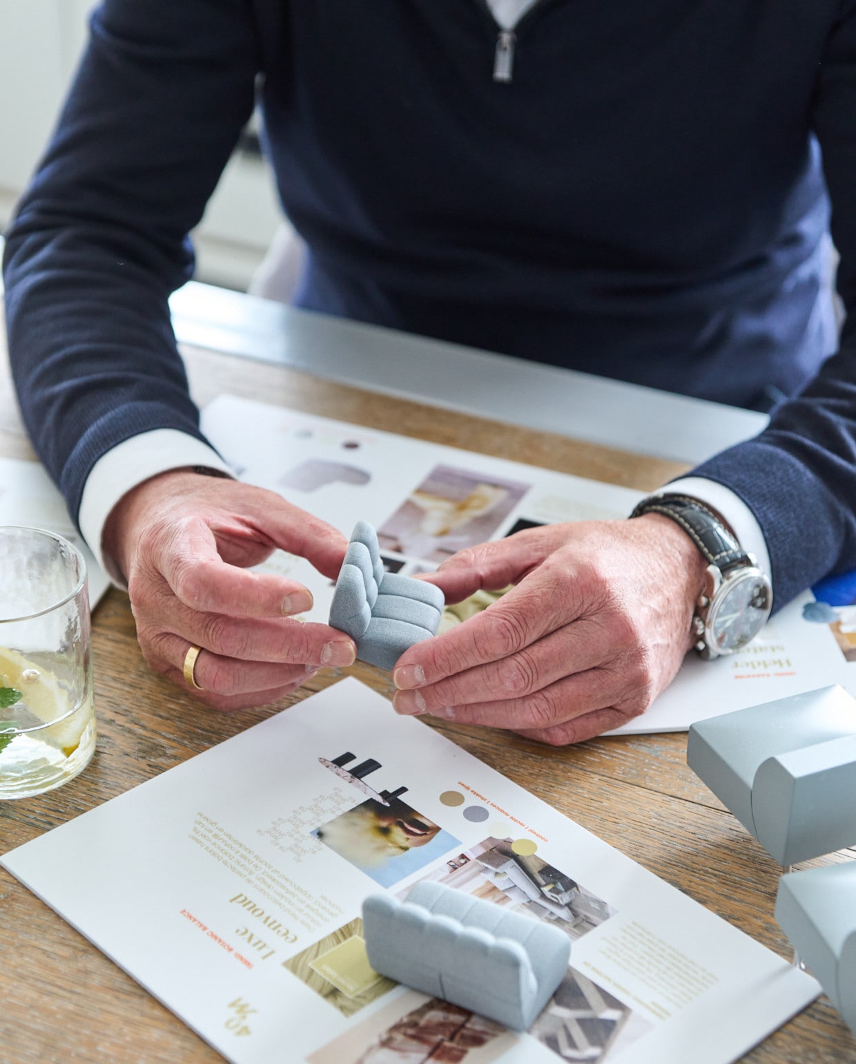 Designer Bram Nijman in de ontwerpstudio van Montèl met miniatuurmodellen van de jubileumcollectie.