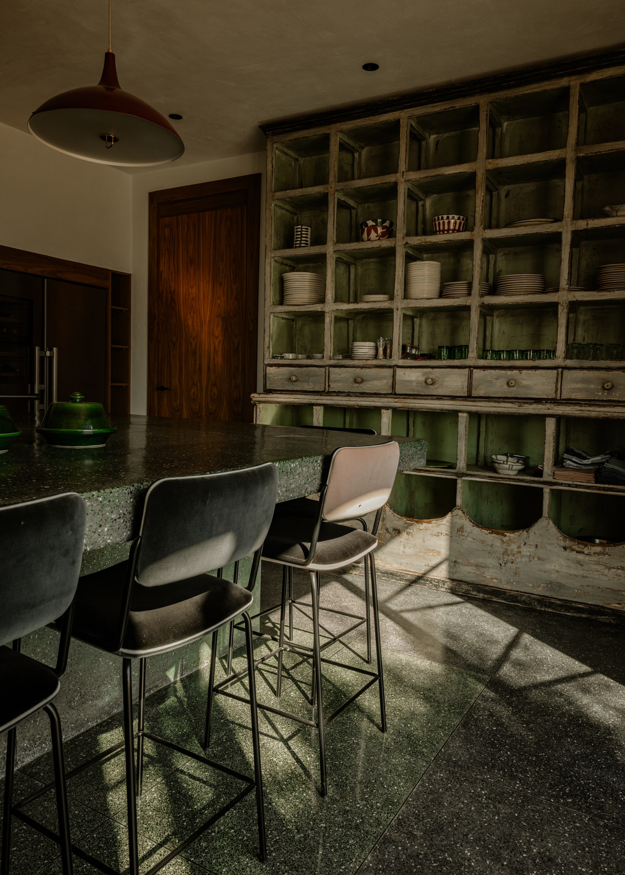 Stoelen en aardewerk in kast Maison Sarah Lavoine. Buffetkast vintage. Plafondlamp Gubi. Terrazzo vloertegels lokaal gekocht. Groene tajine van de lokale beldi-markt. vtwonen Design 07-2026 | fotografie Karel Balas | productie Vega Mg