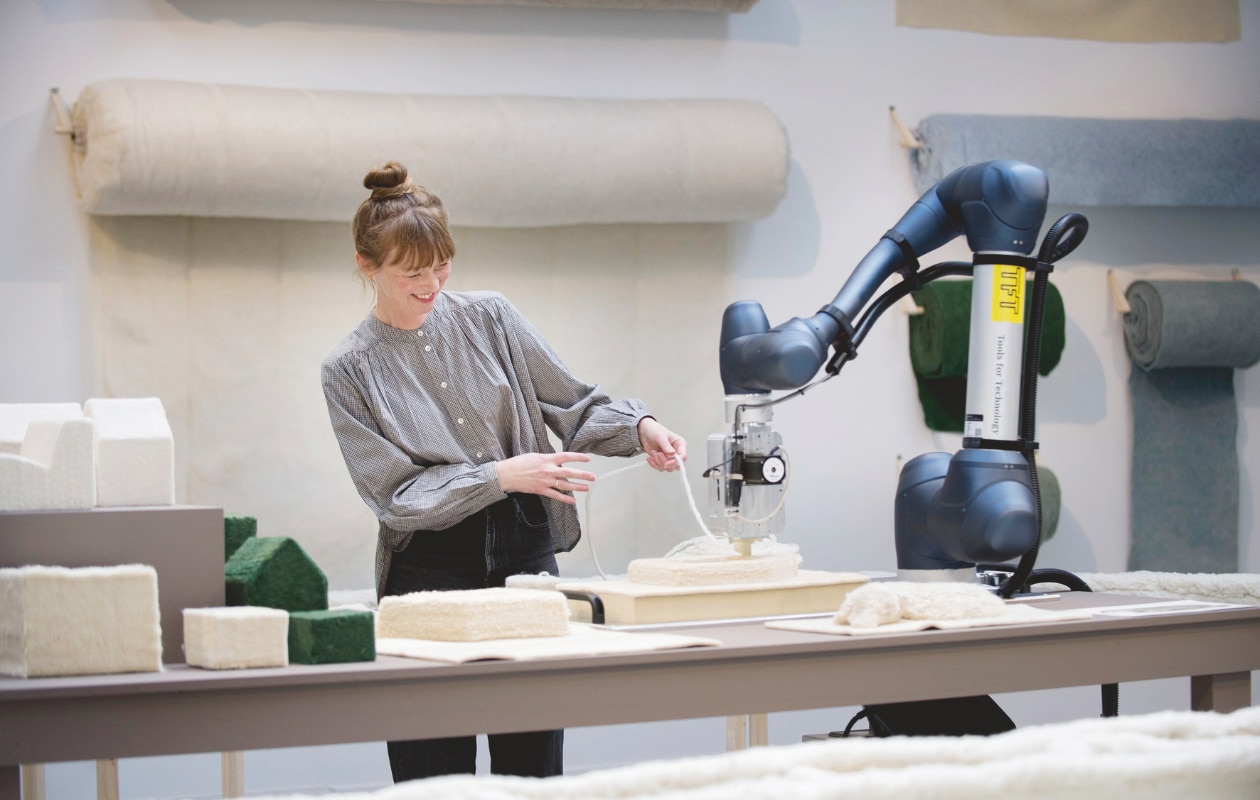 Christien aan de slag met Flocks Wobot, een 3D-gevilt wandpaneel in opdracht van De Her / Gemeente Rotterdam en de volledig geprinte bank. vtwonen design 03-2026 | fotografie Maartje van Berkel