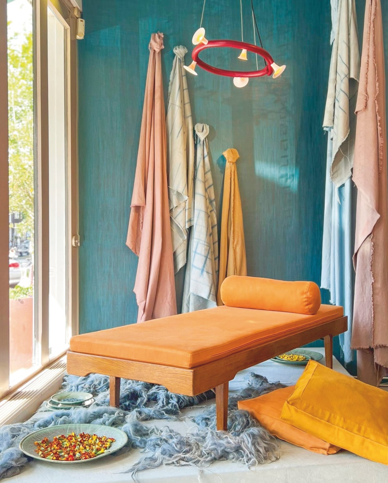 Studies met wol. Botanische fresco voor het plafond van de Pleinfoyer van het Internationaal Theater Amsterdam. Kussens en textiel van Loads Collection: natuurlijk gekleurd met bloemen en gemaakt van biodynamisch katoen van Sekem en Nederlandse Drentse heidewol. Het dagbed is geüpcycled. vtwonen design 03-2026 | fotografie Christianne Pietersen