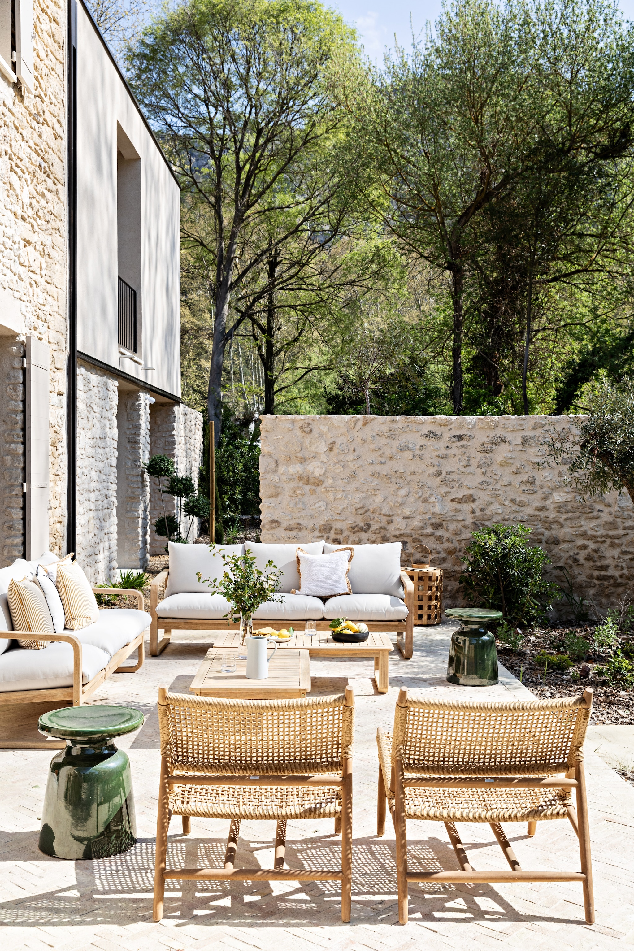 Terrasstoelen, banken en salontafels Sklum. Keramieken bijzettafels Kave Home. Zwarte schaal H&m Home. Gestreept kussen Maison de Vacances. Servies Ikea. vtwonen 08-2026 | styling Marie-Maud Levron | fotografie Yann Deret