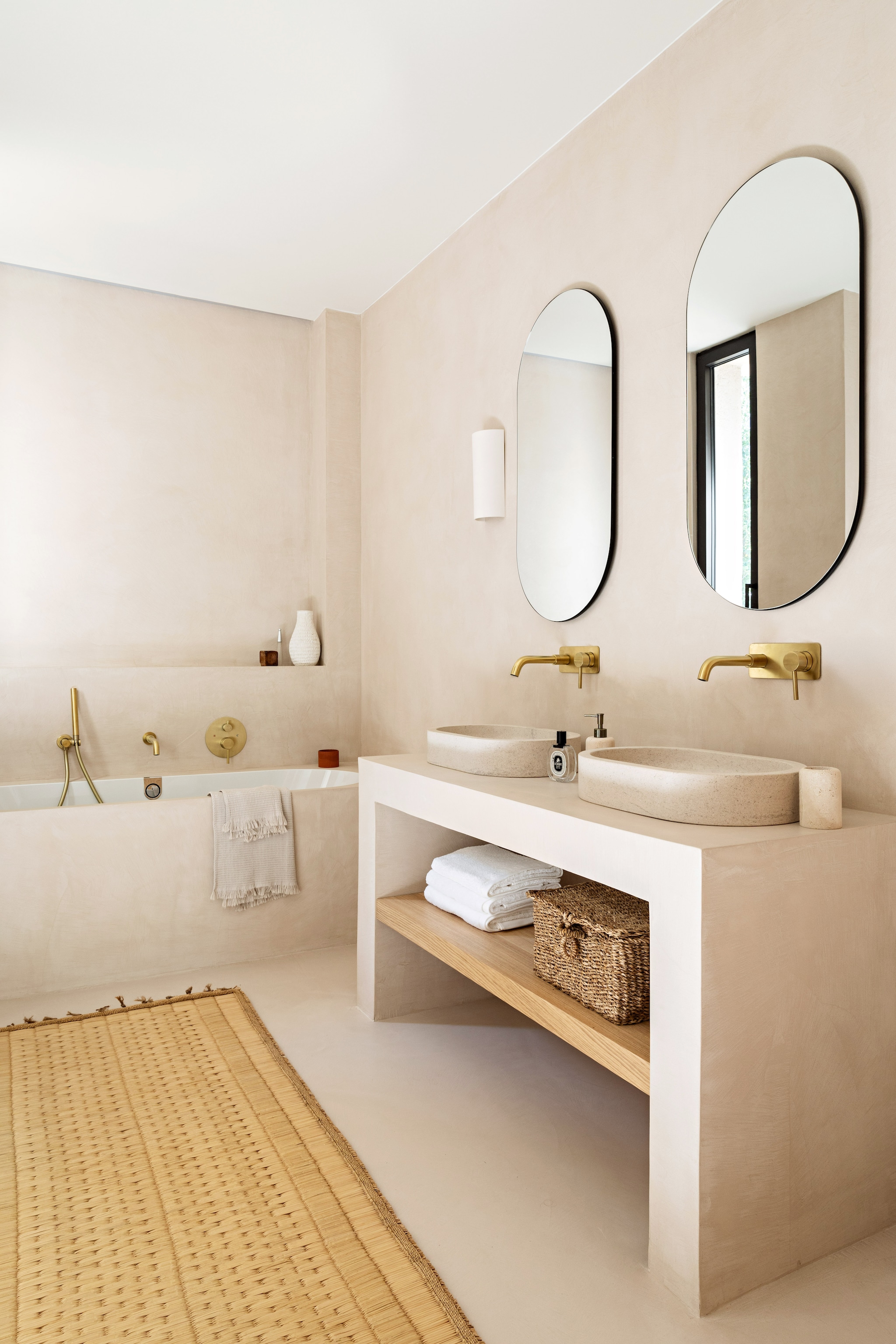Wastafel en badombouw maatwerk. Vergelijkbare kraan Hotbath. Spiegels Ikea. Vloerkleed Cfoc. Vaas Zara Home.  vtwonen 08-2026 | styling Marie-Maud Levron | fotografie Yann Deret