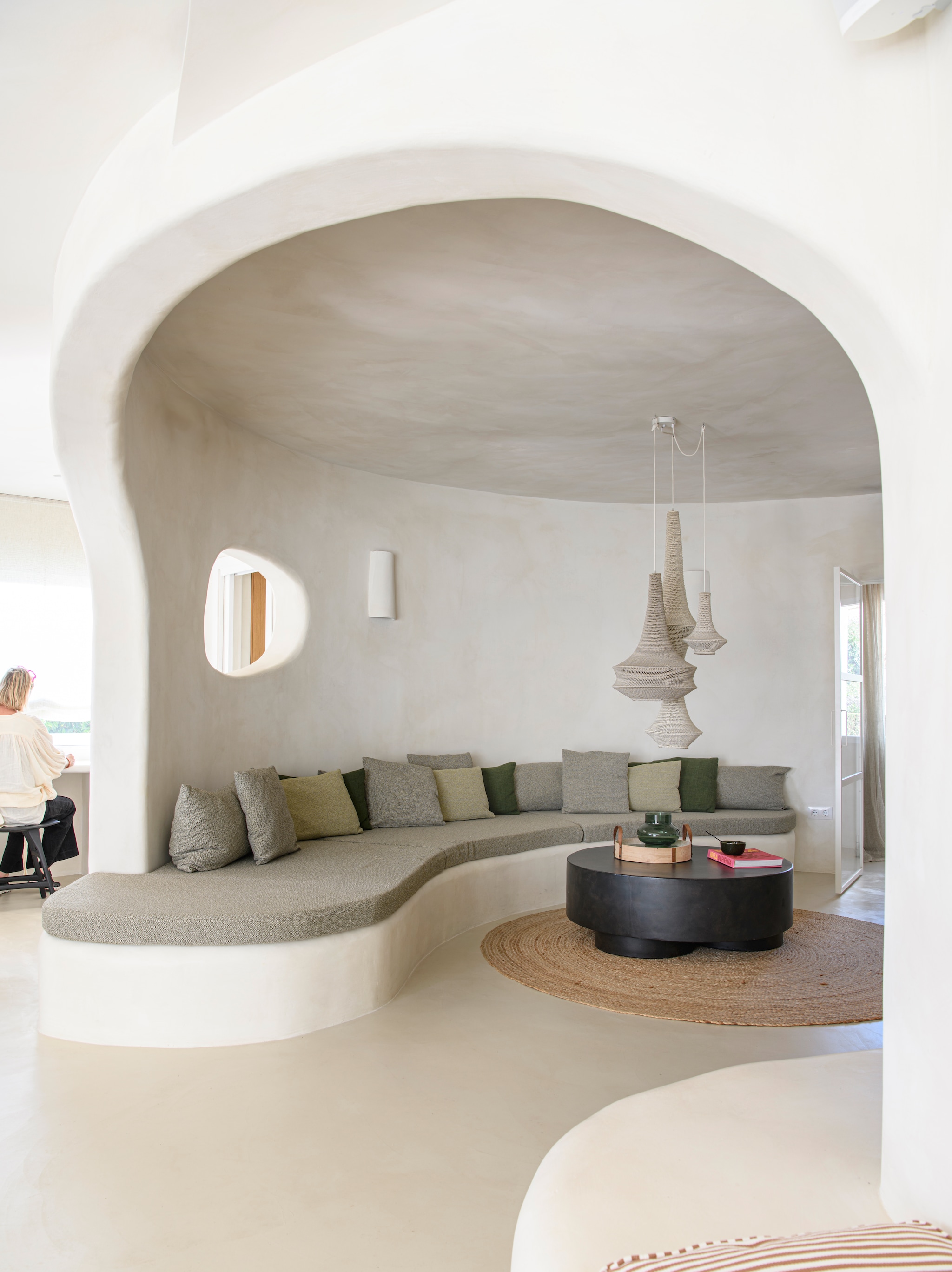 Microcementvloer Topciment. Muren en maatwerk zitbank geverfd met kalkverf Chalk van Bauwerk Colour. Vloerkleed maatwerk. Koffietafel Tine K Home. Hanglampen Hamimi Design. vtwonen 08-2026 | styling Inge van Lieshout | fotografie Louis Lemaire | productie Insidehomepage