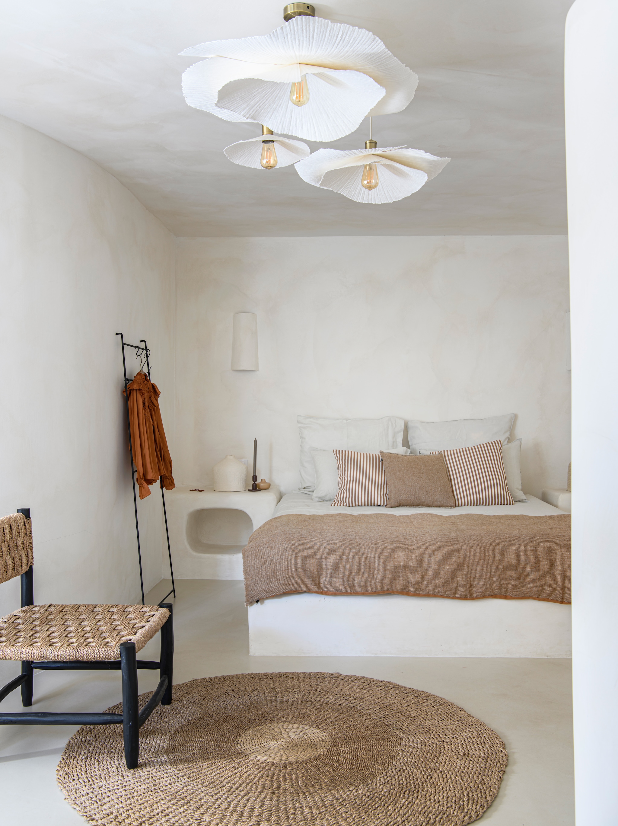 Microcementvloer Topciment. Muren en maatwerk bed en nachtkastjes geverfd met kalkverf Chalk van Bauwerk Colours. Hanglampen, beddengoed Zara Home. Plaid, effen kussen Haomy. Gestreepte kussens maatwerk van outdoor stoffen. Vintage vloerkleed via Bohome Vintage. Stoel Tine K Home. vtwonen 08-2026 | styling Inge van Lieshout | fotografie Louis Lemaire | productie Insidehomepage