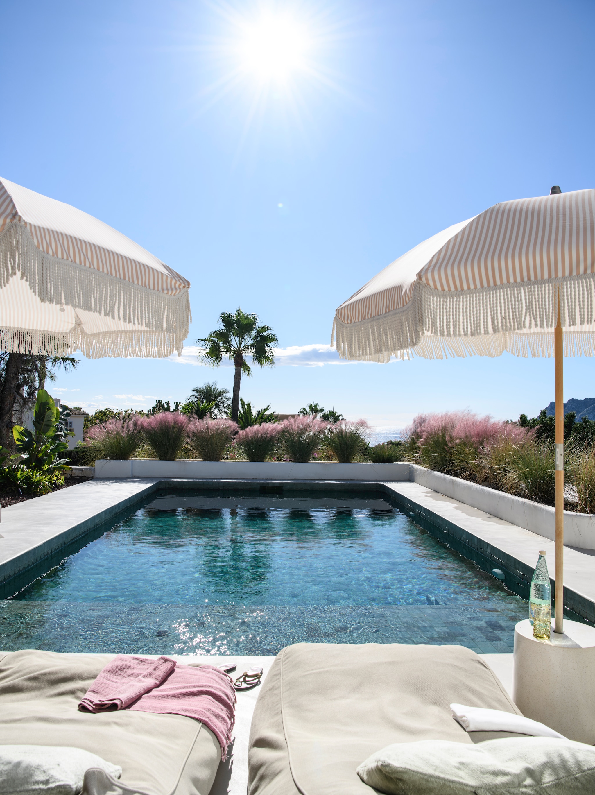 Zoutwaterzwembad betegeld met smaragdgroene, natuurstenen Sukabumi-tegels uit Indonesië. Ligbedden maatwerk. Hoofdkussens Haomy. Parasols HKliving. Tuinontwerp Toni Ballester. vtwonen 08-2026 | styling Inge van Lieshout | fotografie Louis Lemaire | productie Insidehomepage