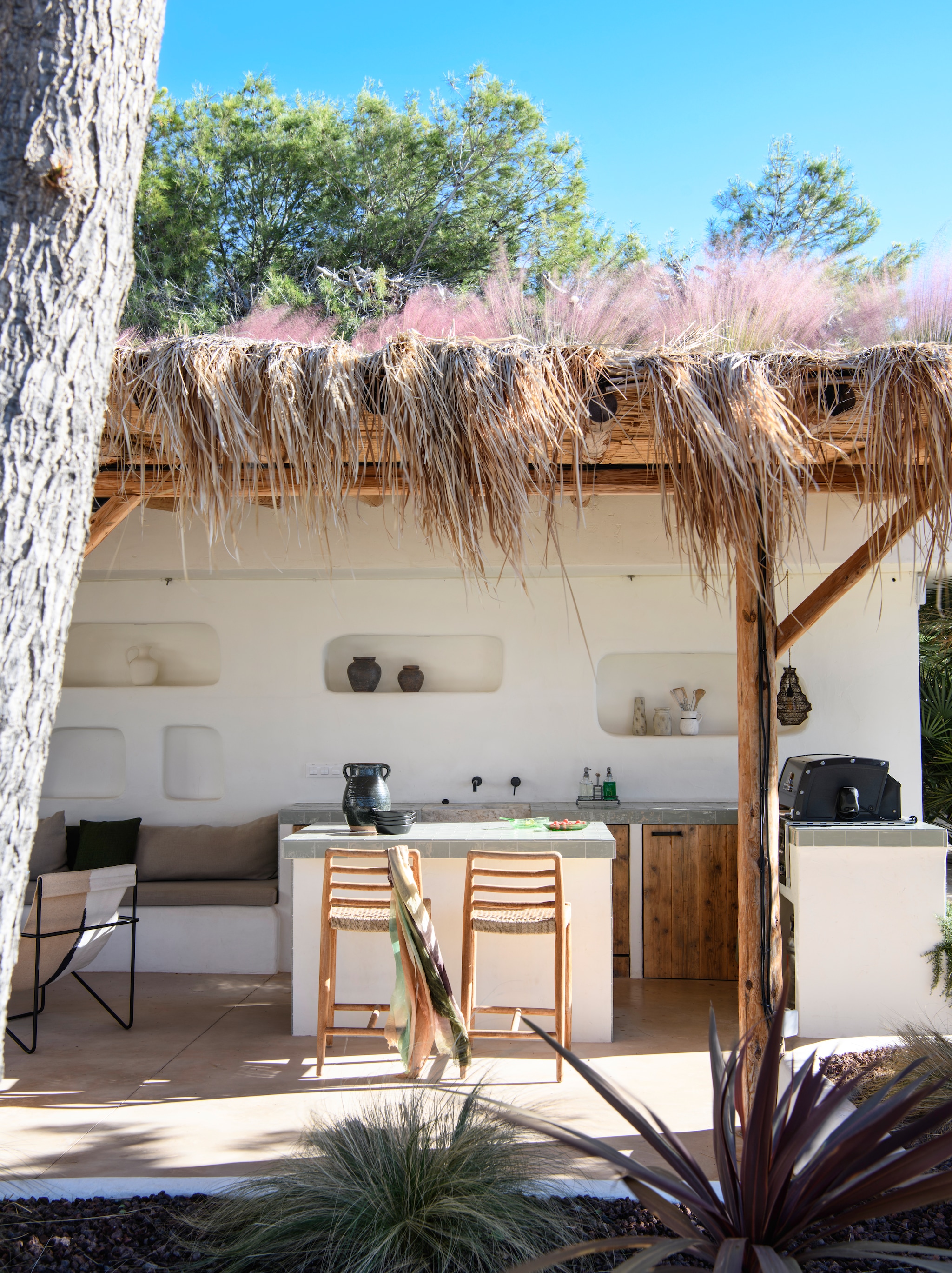 Maatwerk buitenkeuken afgewerkt met microcement Topciment. Tegels uit serie Cotswold van Natucer. Krukken Vical Home. Loungestoel Ferm Living. vtwonen 08-2026 | styling Inge van Lieshout | fotografie Louis Lemaire | productie Insidehomepage