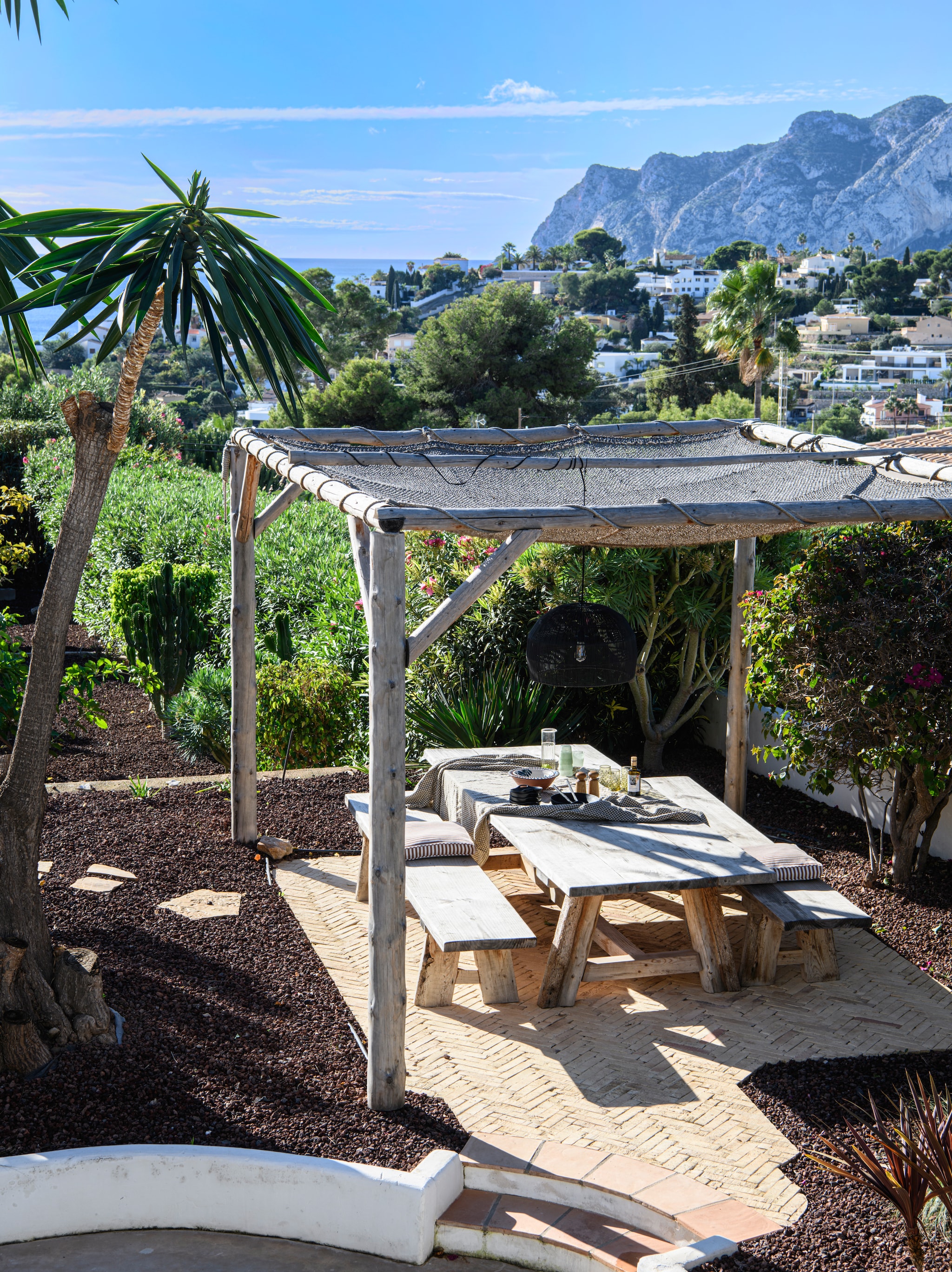Pergola op maat gemaakt met houten staanders uit Noord-Spanje. Tafel en banken op maat gemaakt door @el.secreto.de.la.madera. Kokosdoek Les ombrières de Provence.