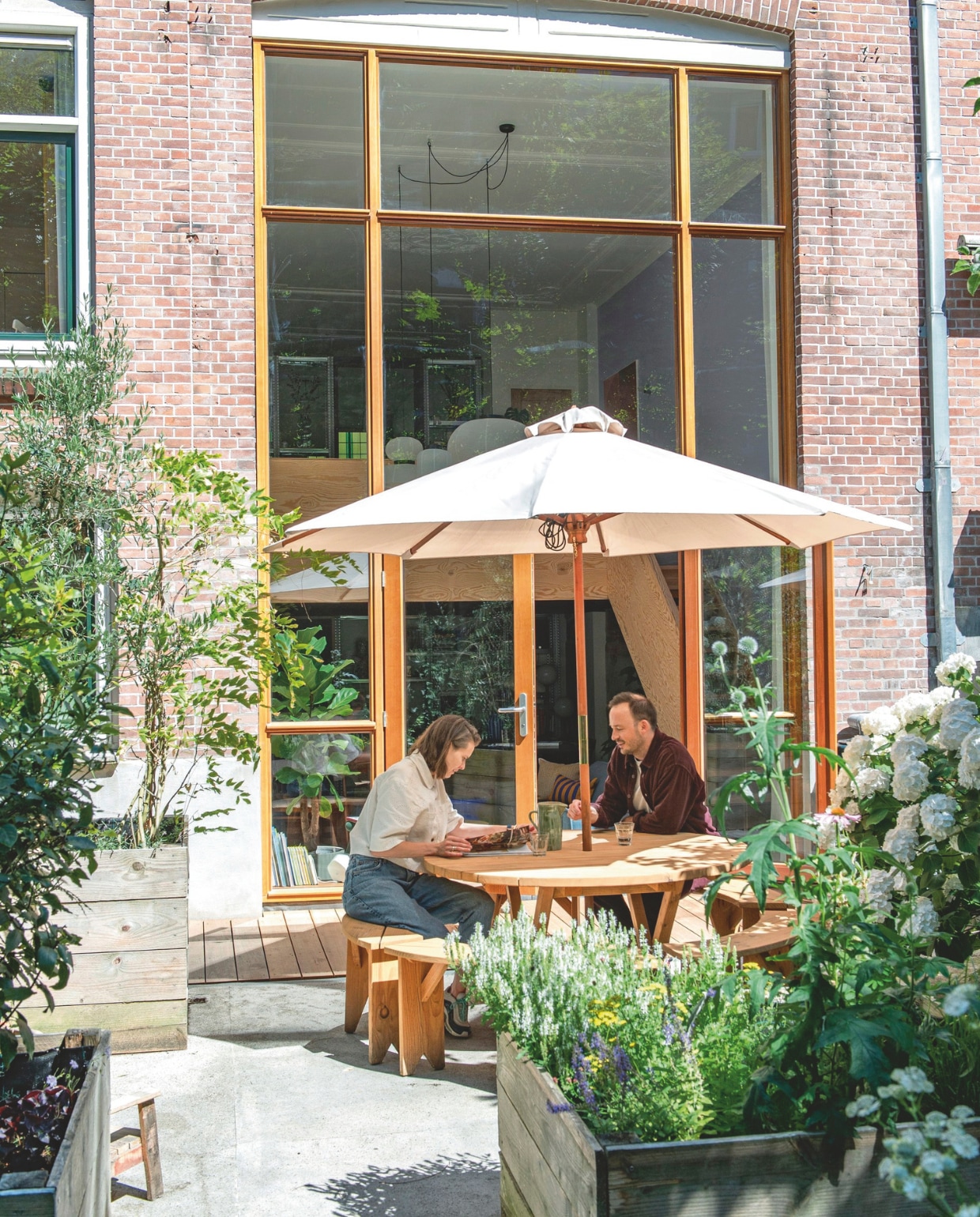 Vloerplanken van kapur- hardhout. Bloembakken van douglashout. Tuinset zelf ontworpen, gemaakt door Warns Woodworks. Parasol Jardi. vtwonen 05-2026 | fotografie Caroline Coehorst