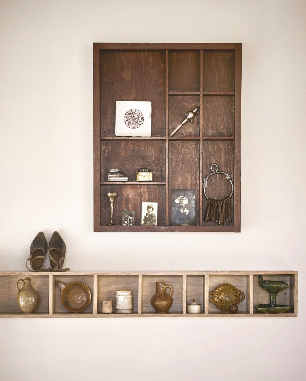 Robbé Studio letterbak Altar of Memories, grenenhout, bruin, 50x65 cm (bxh) € 140,- (robbestudio.com). Antieke tegel, aardewerk en mangaan € 65,-, antiek pillendoosjes, zilver, vanaf € 85,-, rammelaar uit 1879, zilver € 895,-, 19e-eeuws vaasje, zilver € 95,-, 19e-eeuwse oorkruik, aardewerk, bruin, € 65,-, 17e-eeuwse steelpan, aardewerk, bruin € 140,-, 19e-eeuws zalfpotje, aardewerk, geel € 65,-, 17e-eeuws Delfts wit potje, aardewerk, wit € 195,-, 17e-eeuwse kruik, aardewerk, bruin € 145,-, 17e-eeuws vergiet, aardewerk, bruin € 195,-, 17e-eeuwse knikker, aardewerk, bruin € 20,-, 17e-eeuwse oliebrander, aardewerk, groen € 650,- (kramer.amsterdam). Sleutelbos, metaal, bruin € 42,50, Klompjes € 45,- (@munkantiques). vtwonen wandkast Show It, mdf, naturel fineer, 130x16x12 cm (lxbxd) € 89,95 (shop.vtwonen.nl). Weldaad pot, hars en messing, wit € 19,95 (weldaad.com). Overig privébezit. vtwonen landelijk 6-2026 | styling Marianne Luning | fotografie Alexander van Berge