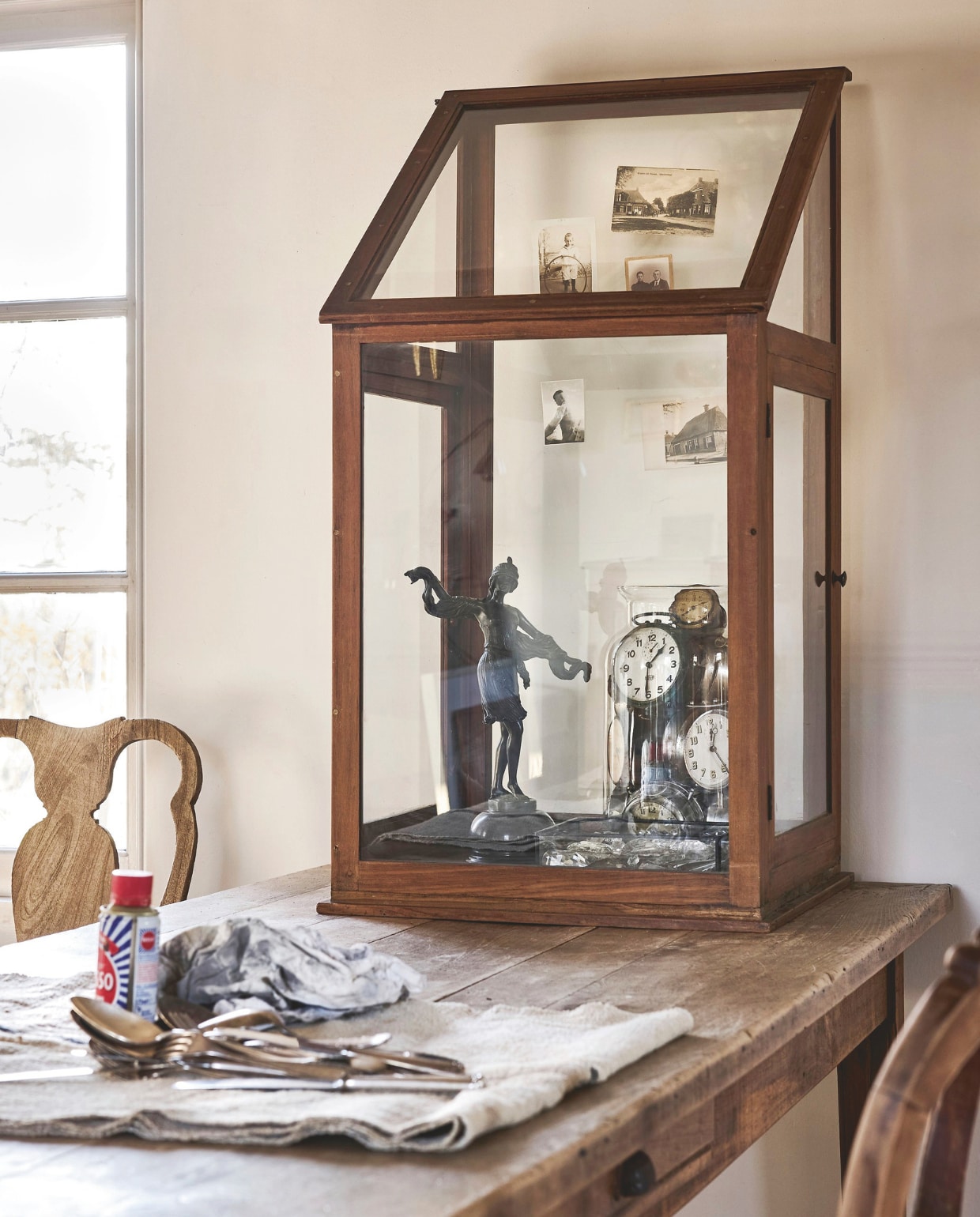 Weldaad vitrinekast, glas en hout, bruin, 80x35x110 cm (bxdxh) € 450,-, kristallen kroonluchterhangers, per stuk € 5,-, stoel, hout, bruin, 45x45x105 (bxdxh) € 695,- (weldaad.com). 20e-eeuwse sculptuur, brons en marmer € 650,- (kramer.amsterdam). Klokken-verzameling in vaas, metaal en glas, prijs op aanvraag (@munkantiques). Overig privébezit. vtwonen landelijk 6-2026 | styling Marianne Luning | fotografie Alexander van Berge