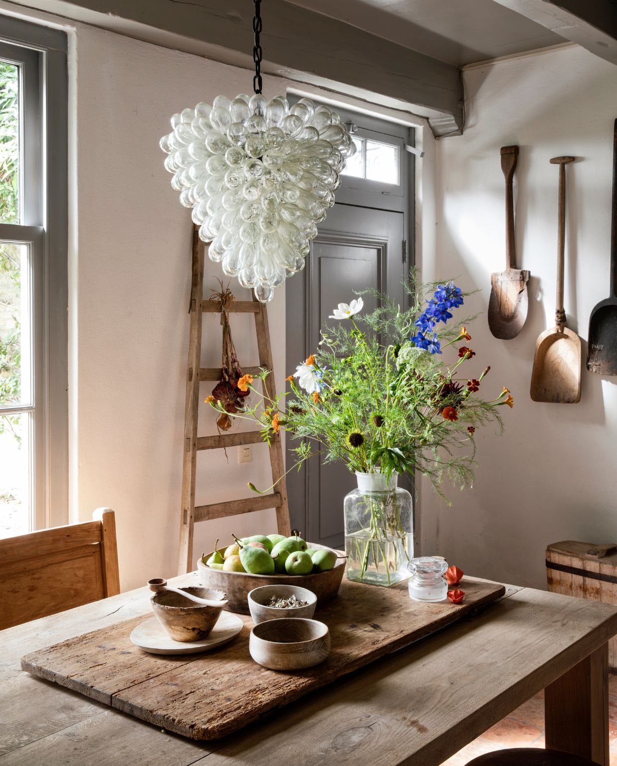 Eettafel Het kabinet. Hans maakte de kastdeuren met hout van oude goederenwagons dat werd gezandstraald. Antieke spades opgehangen als decoratie. Ladder brocante. Kommen op tafel HKliving.