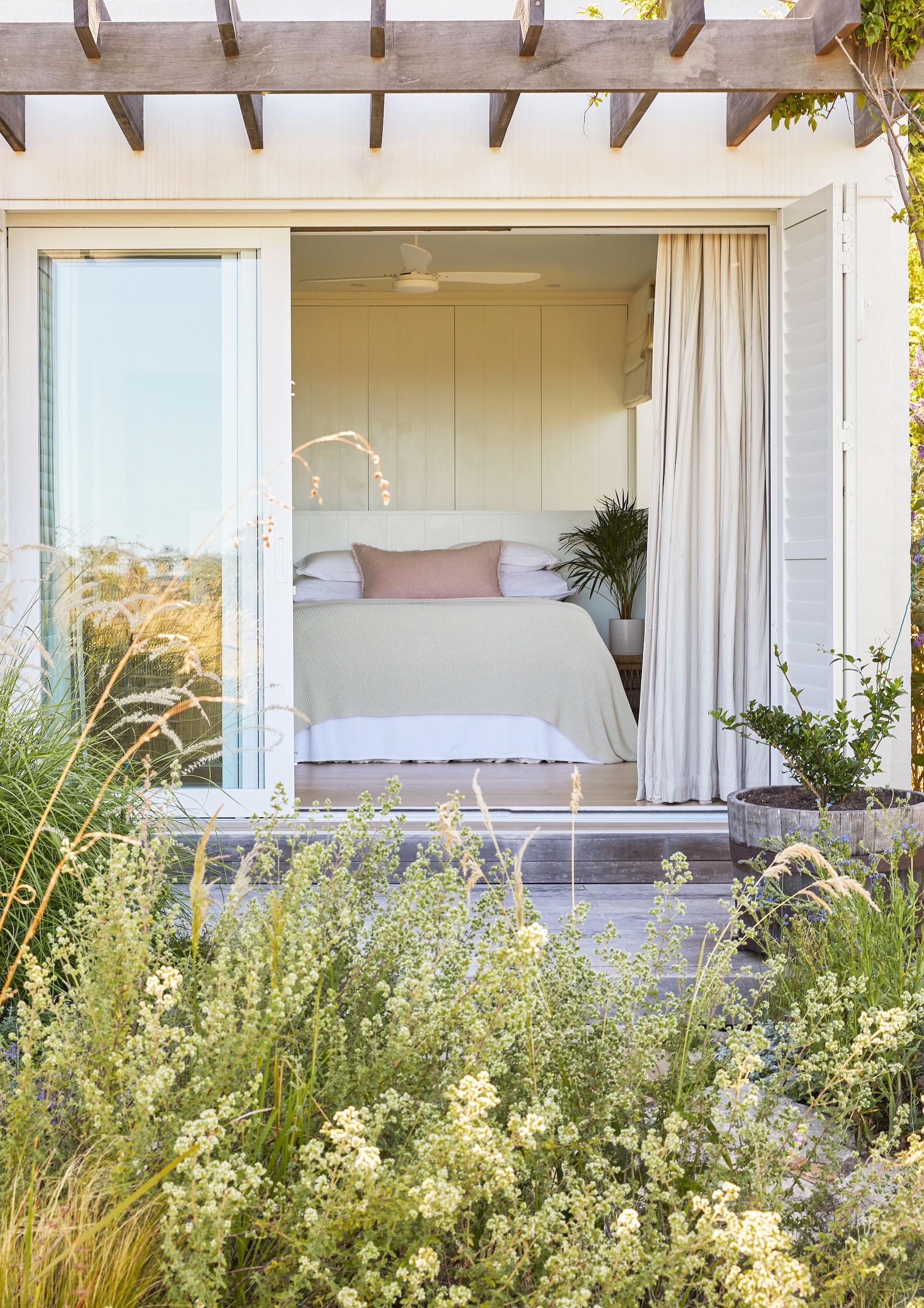 Vergelijkbaar kussen Maisons du Monde. Wijnvat als bloembak Tas Boomkwekerij. De pergola raakt geleidelijk aan begroeid met klimmende jasmijn. vtwonen Landelijk 08-2026 | fotografie Greg Cox