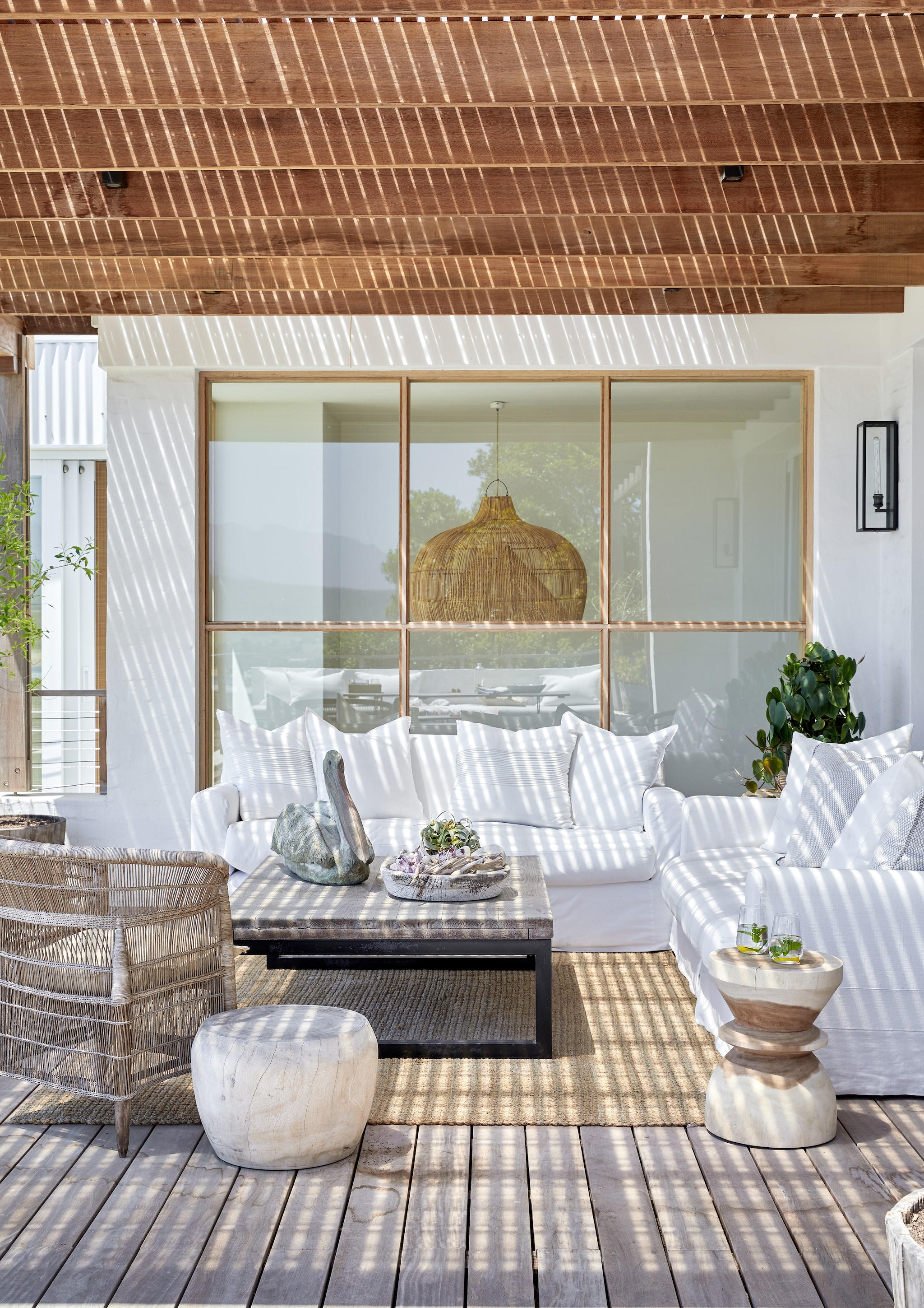 Uitzicht op de bergen, het strand en de rivierdelta: aan de plek mankeert niets. Gevlochten stoel Malawi Cane via Atelier Pomme. Bronzen pelikaan van beeldhouwer Italia Greig. Zitmeubels The Private House Company. vtwonen Landelijk 08-2026 | fotografie Greg Cox