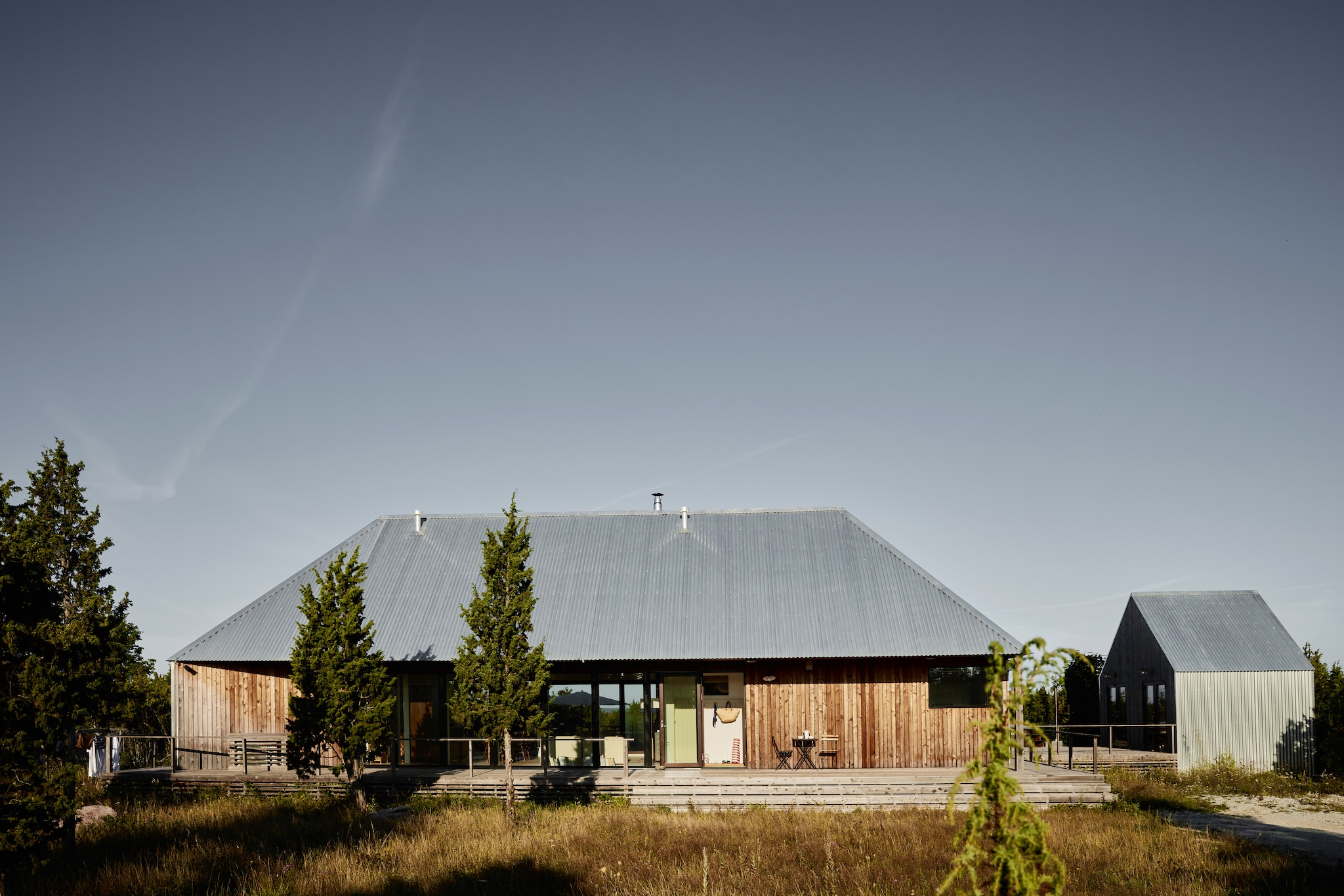 Het huis is omringd door een houten terrasplateau. Bistroset Fermob. vtwonen Landelijk 08-2026 | Fotografie Krista Keltanen | Productie Living Inside