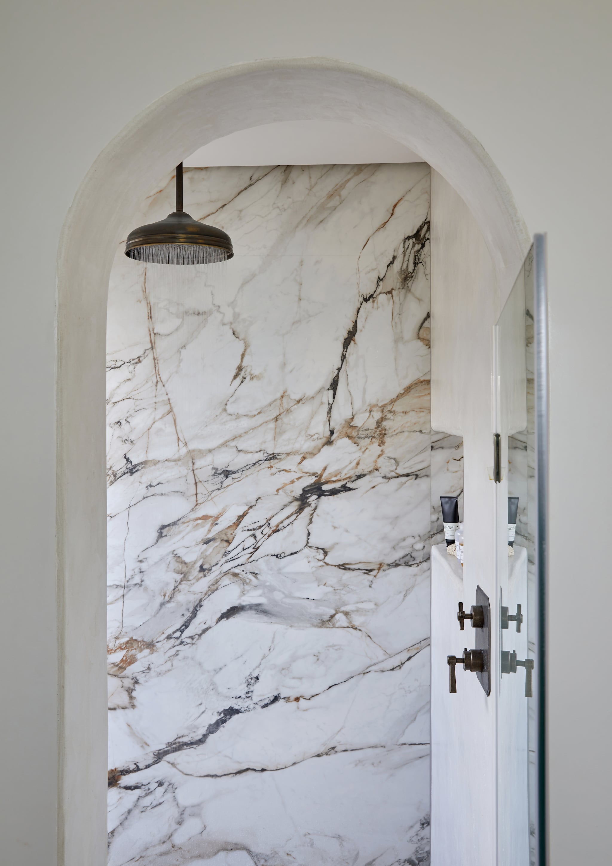 Douchewanden bekleed met marmer. Vergelijkbaar marmer met beige aders Calacatta extra van Ariës Natuursteen of Calacatta Vagli van Splendore Stone. Vind marmeren wandpanelen bij Benacci of Tegel en Natuursteen Brabant. vtwonen landelijk 8-2026 | Styling Luanne Toms | Fotografie Greg Cox