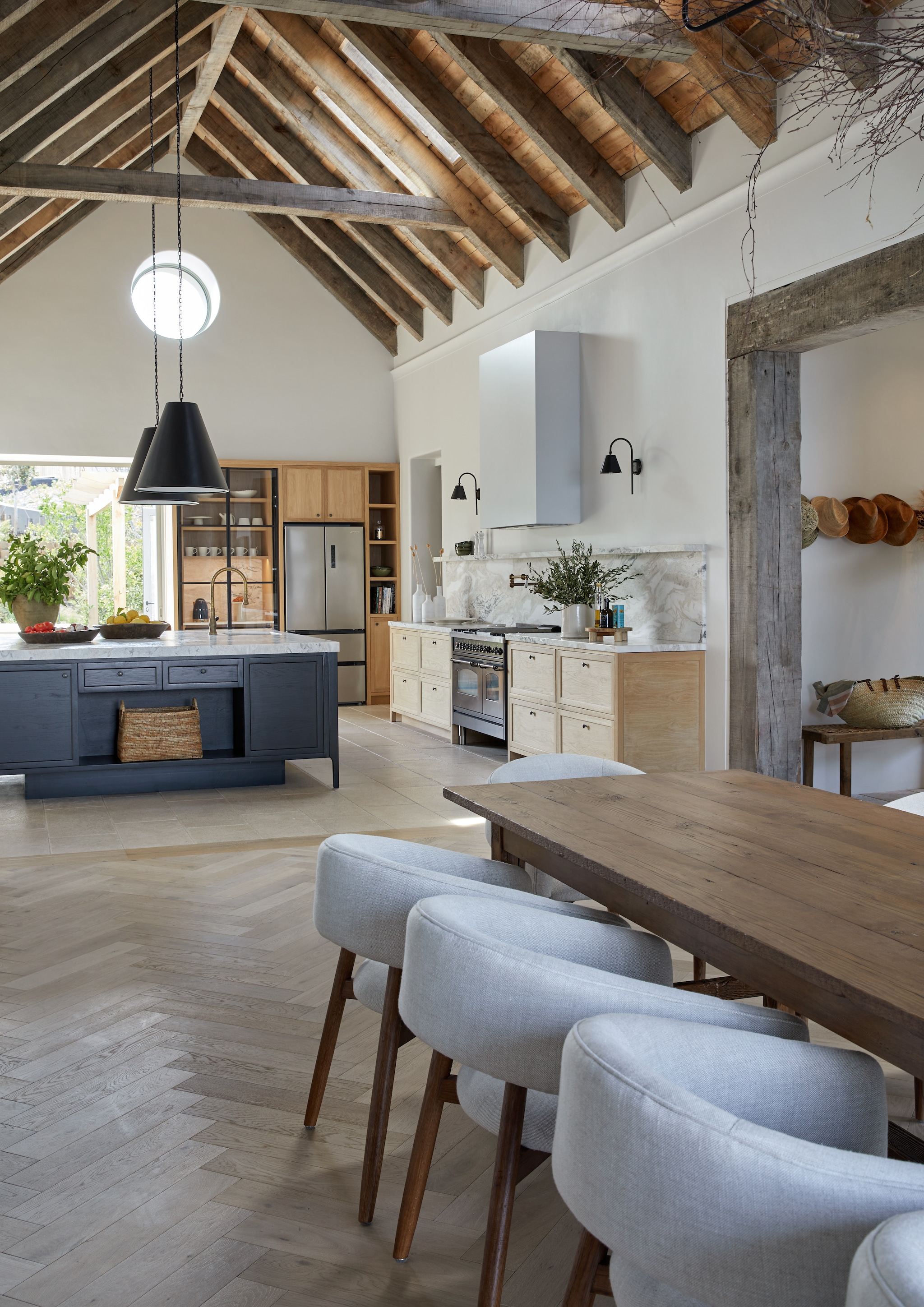Keuken op maat gemaakt van massief eiken met marmeren blad, spatwand en wandplank. Plafond bekleed met ruwe populierplanken. vtwonen landelijk 8-2026 | Styling Luanne Toms | Fotografie Greg Cox
