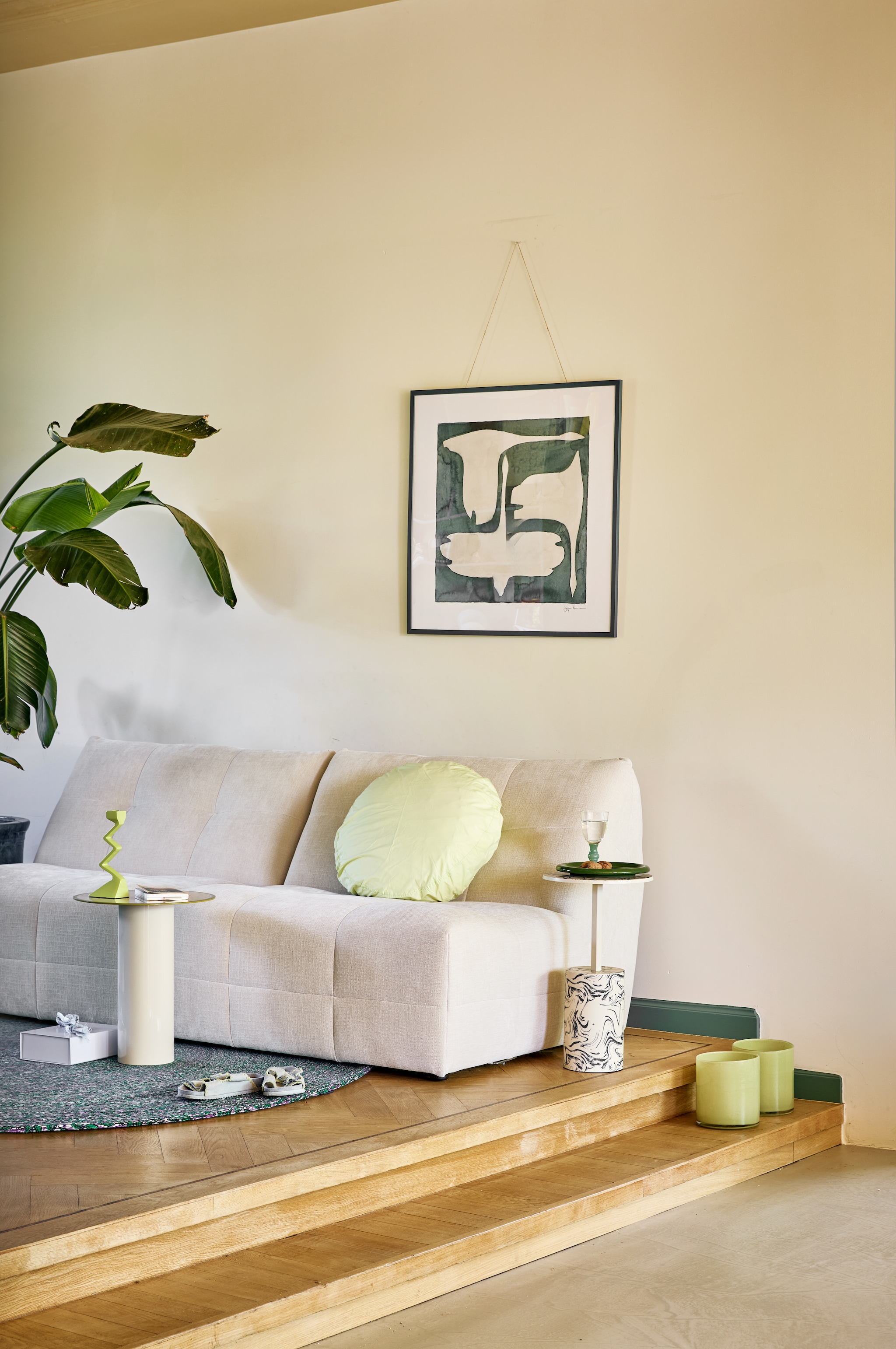 By Sidde bank Molli, polyester, calm beige, 204x102x78 cm (bxdxh) € 1498,- (bysidde.com). Urban Nature Culture bijzettafel Tiro, ijzer, almond milk, 36x42,5 cm (Øxh) € 99,-, bijzettafel Sten, aluminium, staal, beige € 149,-, kandelaar Sigsag, aluminium, groen € 34,99 (shop.vtwonen.nl). Suite 702 kussensloop Big Dot, katoen, pistachio € 44,95 (suite702.com). Hay opbergdoos Colour Storage, karton, lavendel € 12,-, bord Barro, terracotta, groen, set van 2 € 49,- (hay.com). Pstr Studio ingelijst kunstwerk The Swan III van Jörgen Hansson, hout en glas, petrol lijst, 70x50 cm (lxb) € 176,- (pstrstudio.com). Tablewear Amsterdam wijnglas, glas, groen € 12,50 (tableware.amsterdam). Farrow & Ball muurverf Modern Emulsion, school house white, 2,5 L € 119,-, Pure & Original lak plinten Eggshell, country blue, 1 liter € 68,- (labcolourtheworld.com). Overig privébezit.