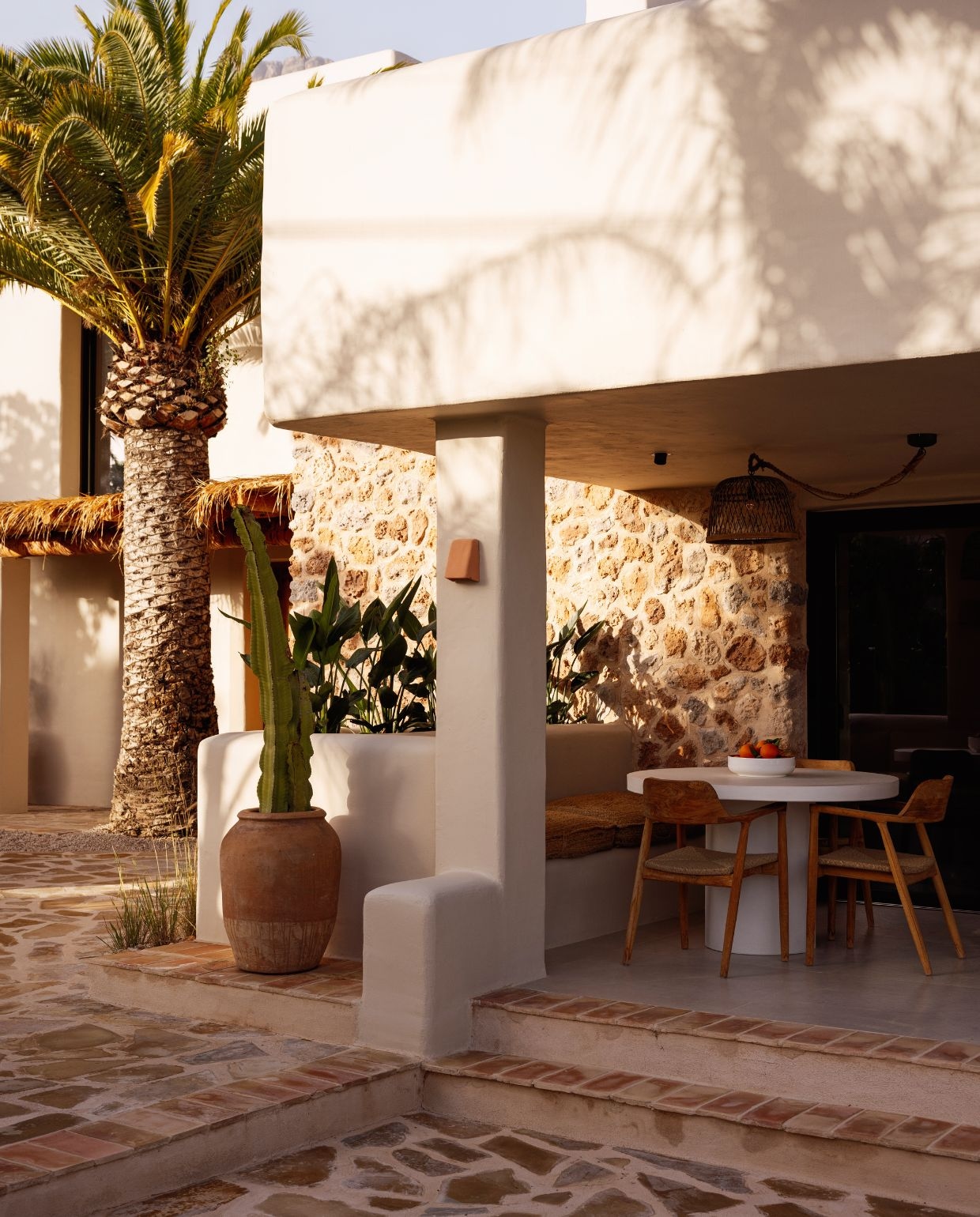 Hanglamp gekocht in Gata de Gorgos. Wandlampen van lokaal keramiek. Pot met cactus antiekmarkt in Jalón. Buitentafel Kave Home. Stoelen Ibiza Outdoor.