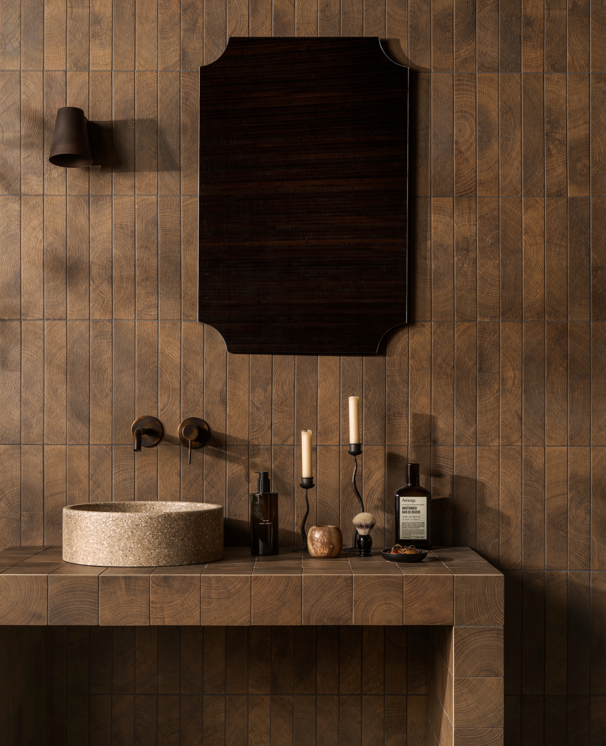 vtwonen vloer- en wandtegel Woodcirkle, keramiek, wenge, 10x10 cm  (lxb) en 30x5,3 cm (lxb), per m2 vanaf € 76,50. M.m.v. detremmerie.nl (waskom).douglasjones.nl (wastafelkraan), zarahome.com (spiegel, wandlamp, kandelaars, zeeppomp). Overig privébezit.