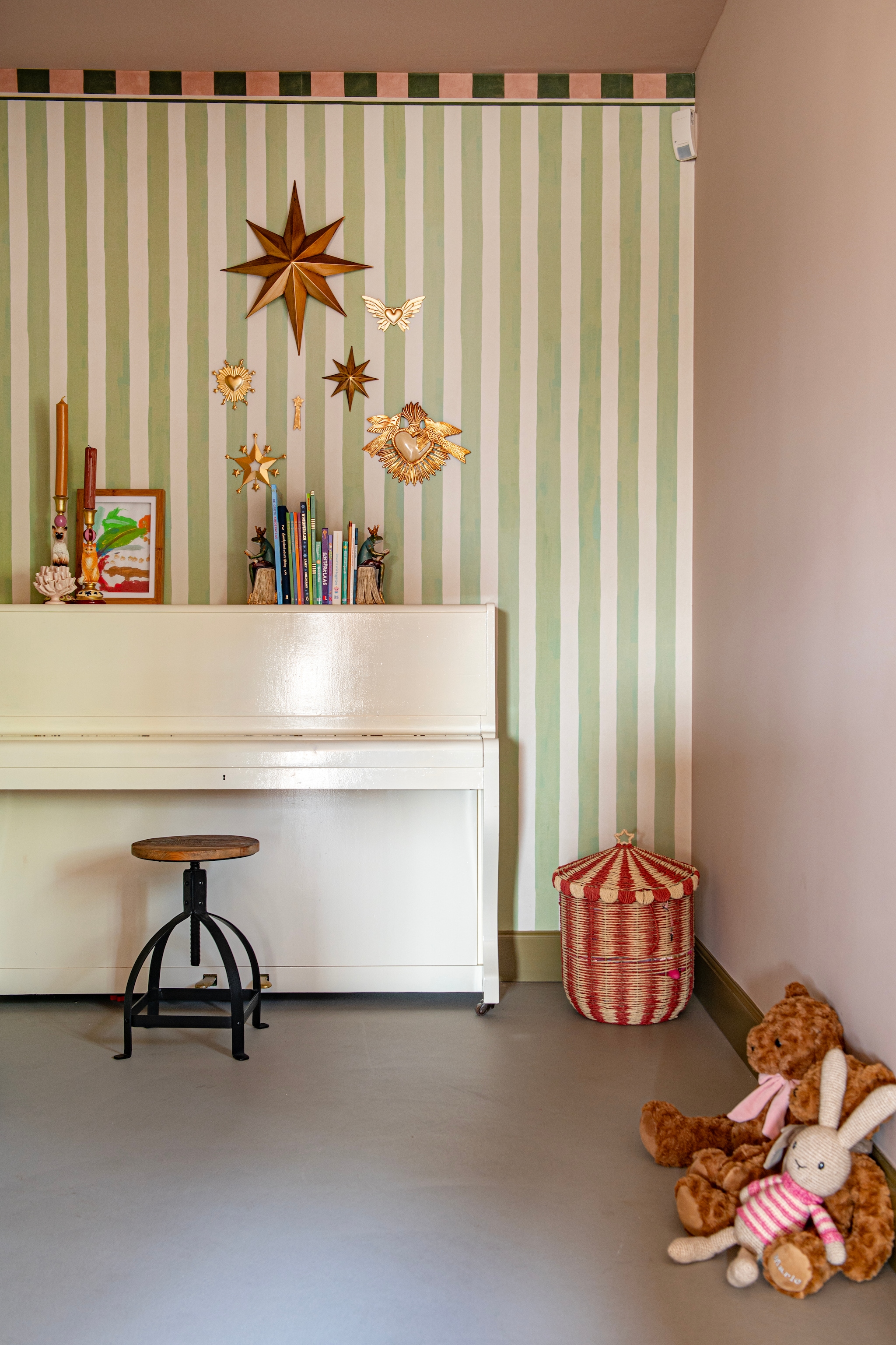 De speelhoek. Behang Belartestudio. Piano en kruk erfstukken. Mand Zara Home. Grote knuffelbeer Birth Bear. vtwonen Special 03-2026 | fotografie Caroline Coehorst | productie De Binnenkijkers by Caroline